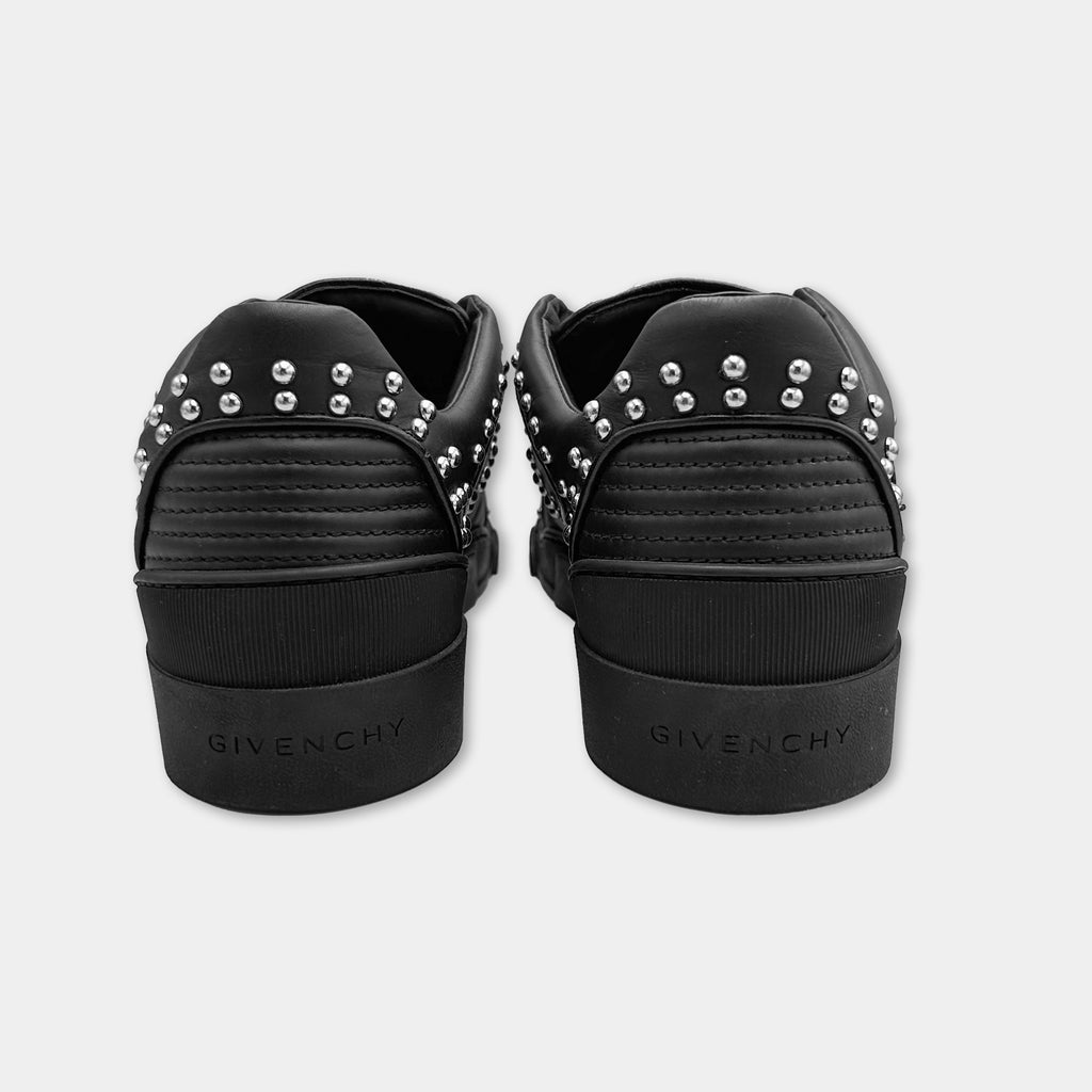 A pair of black sneakers with silver studs on the back.
