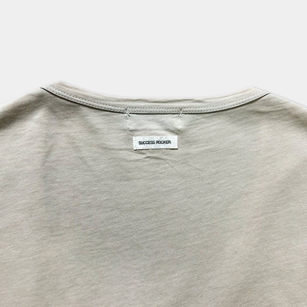a close-up view of a grey t-shirt with a small white label attached to the back.