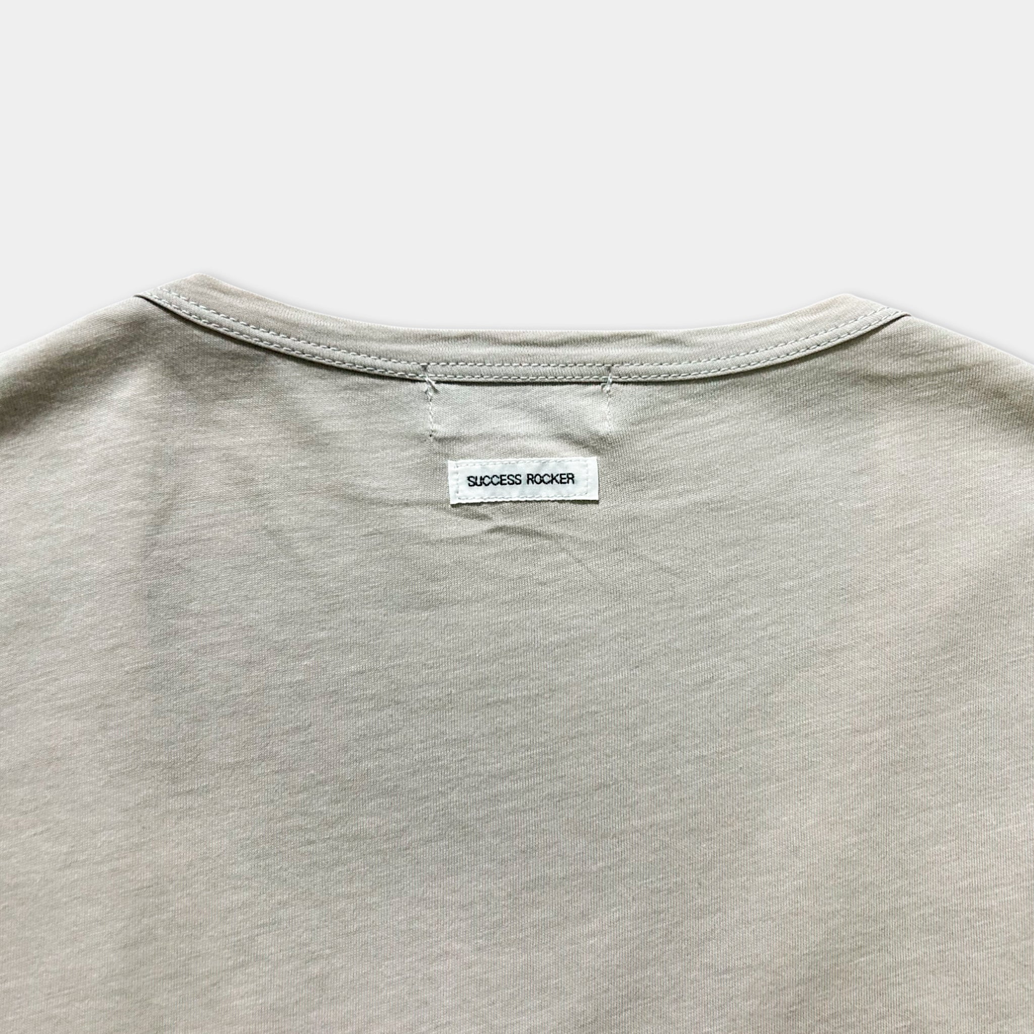 a close-up view of a grey t-shirt with a small white label attached to the back.