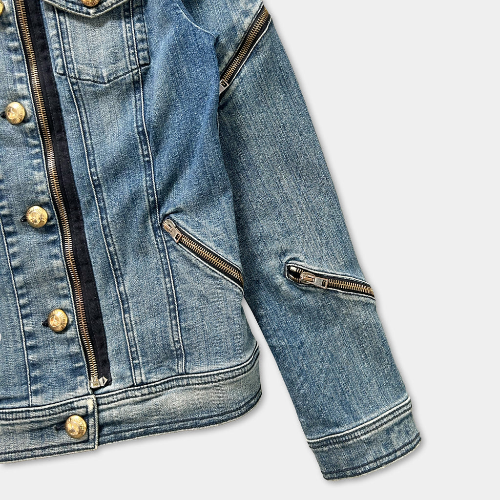 A close-up view of a denim jacket with multiple zippers and buttons.