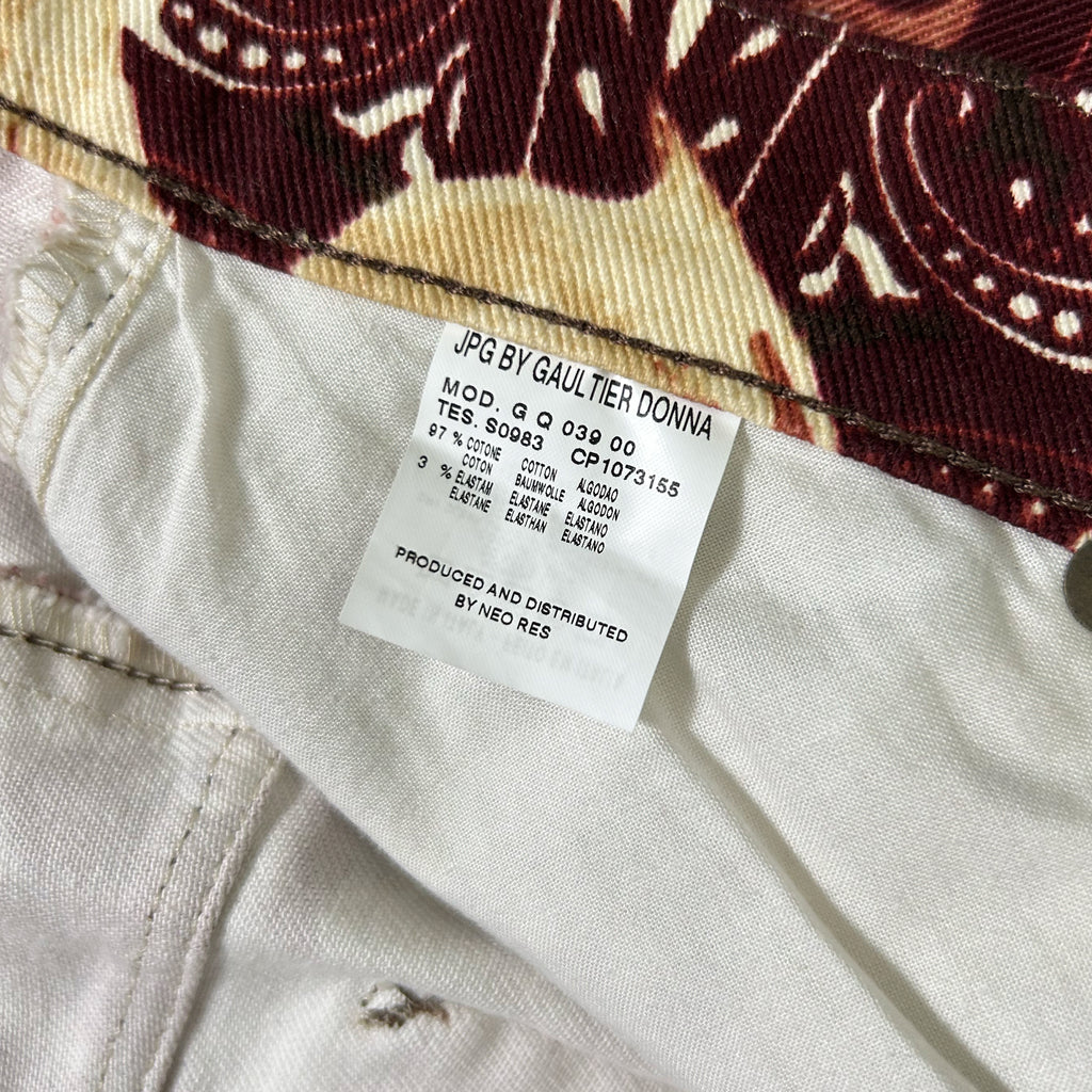a close-up view of a label on a piece of clothing, likely a pair of jeans, with a patterned fabric visible in the background.
