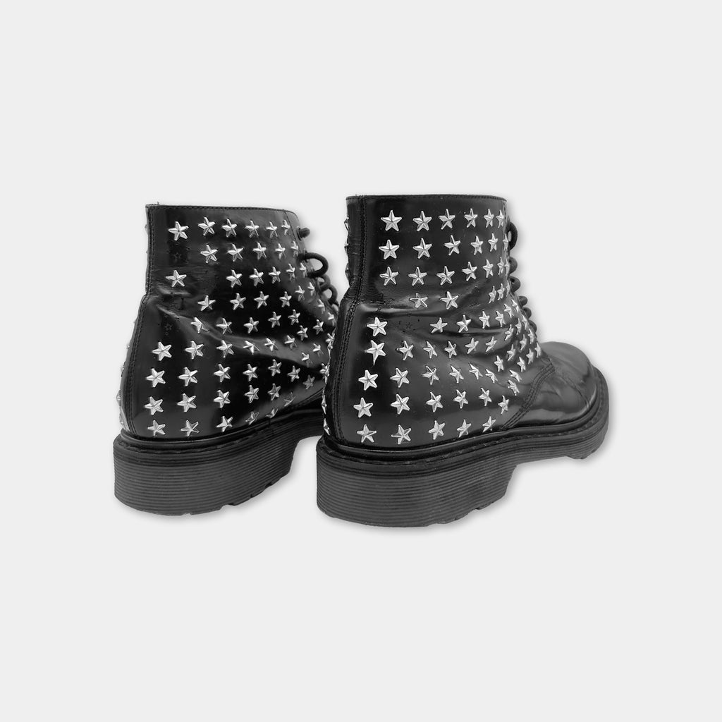 A pair of black leather boots with white star patterns on the side.