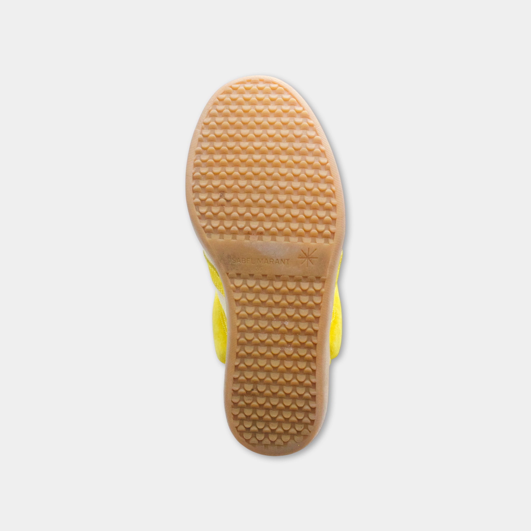the sole of a yellow shoe against a white background.