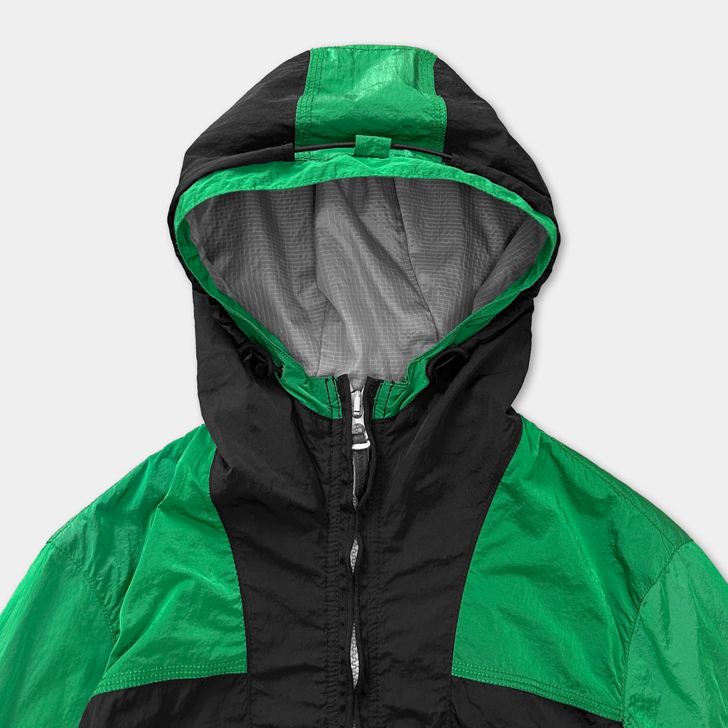 A close-up view of a green and black jacket with a zipper and hood.