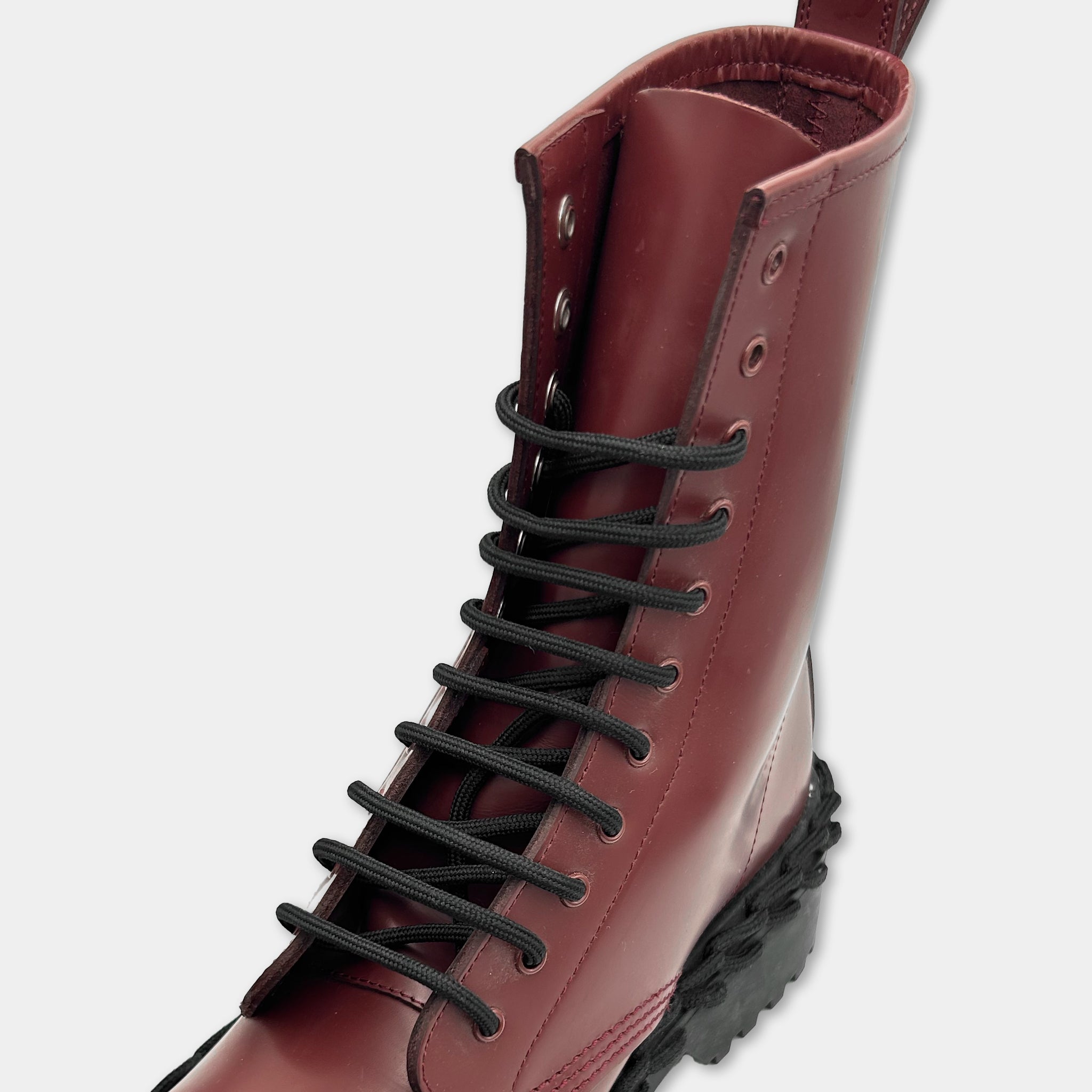A close-up view of a burgundy leather boot with black laces.