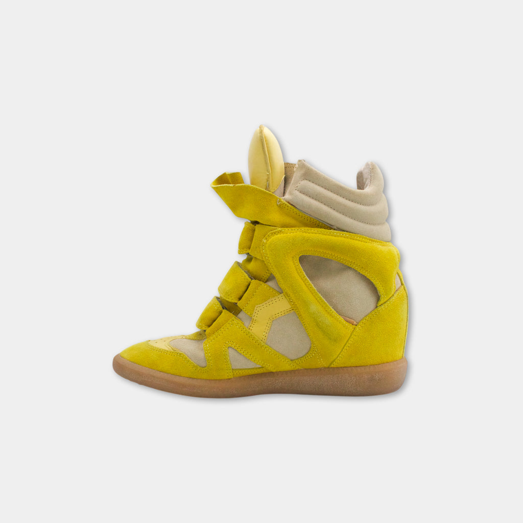 A yellow and beige high-top sneaker with a distinctive design.