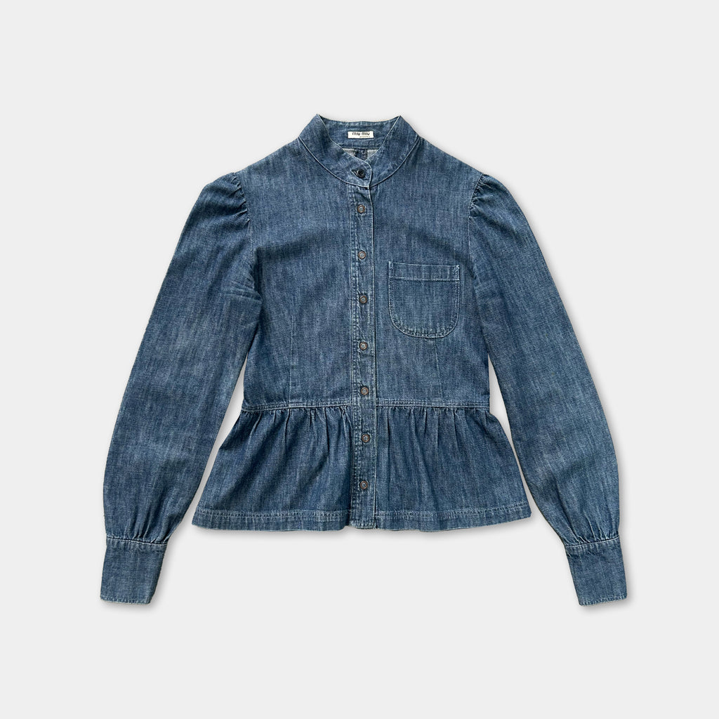 A blue denim button-up shirt with puffed sleeves and a ruffled hemline.