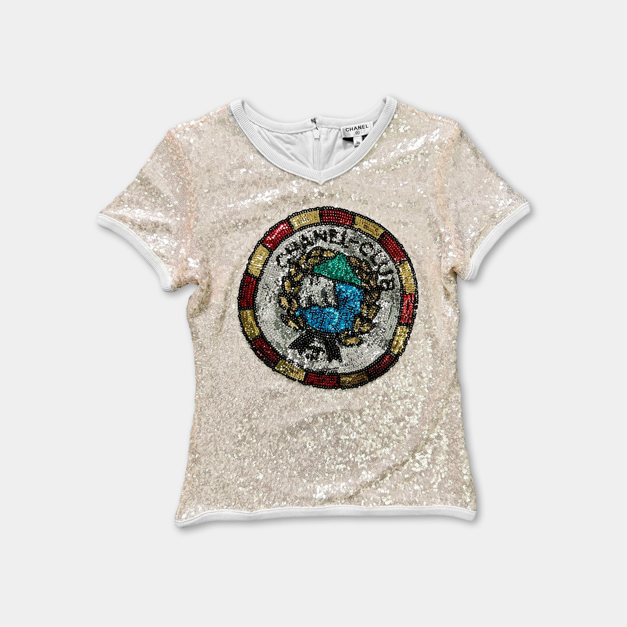 A beige, short-sleeved shirt with a large, colorful, circular logo on the front.