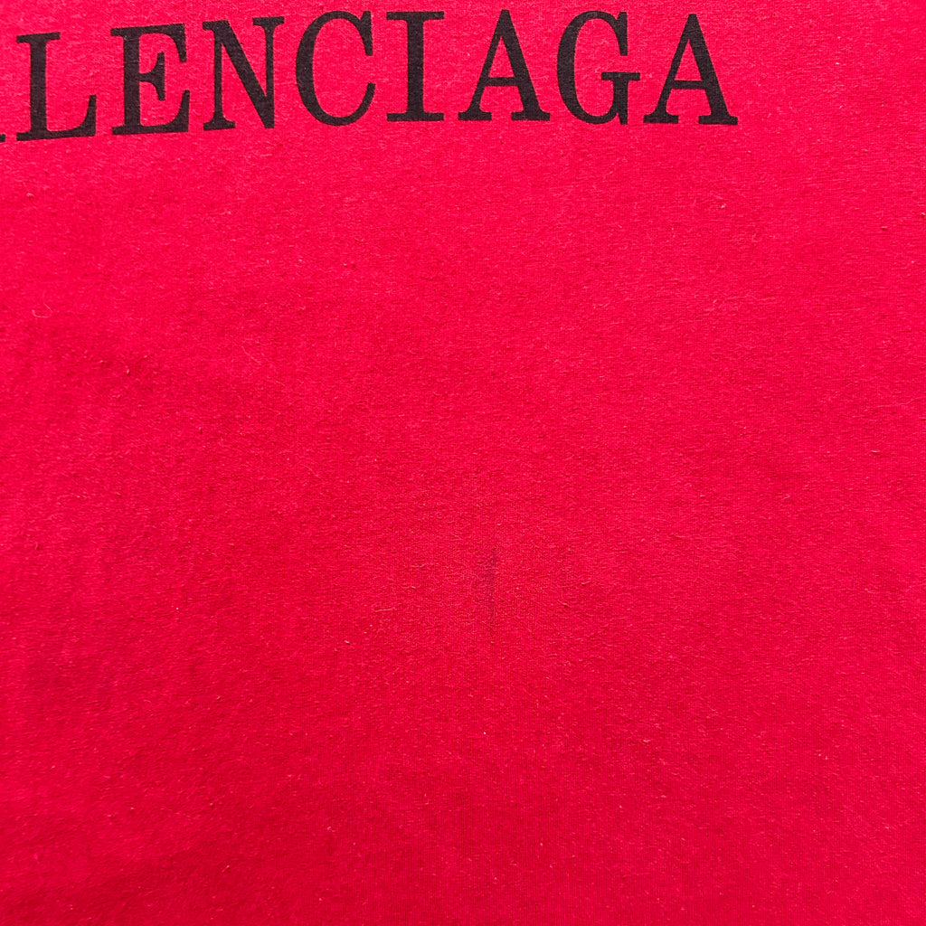 The image is a close-up of a red fabric with the word "LENCIAGA" printed on it in black text.