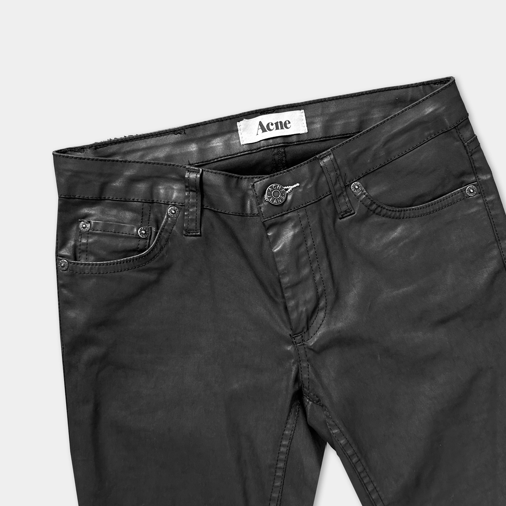 A pair of black leather pants with a label on the waistband.