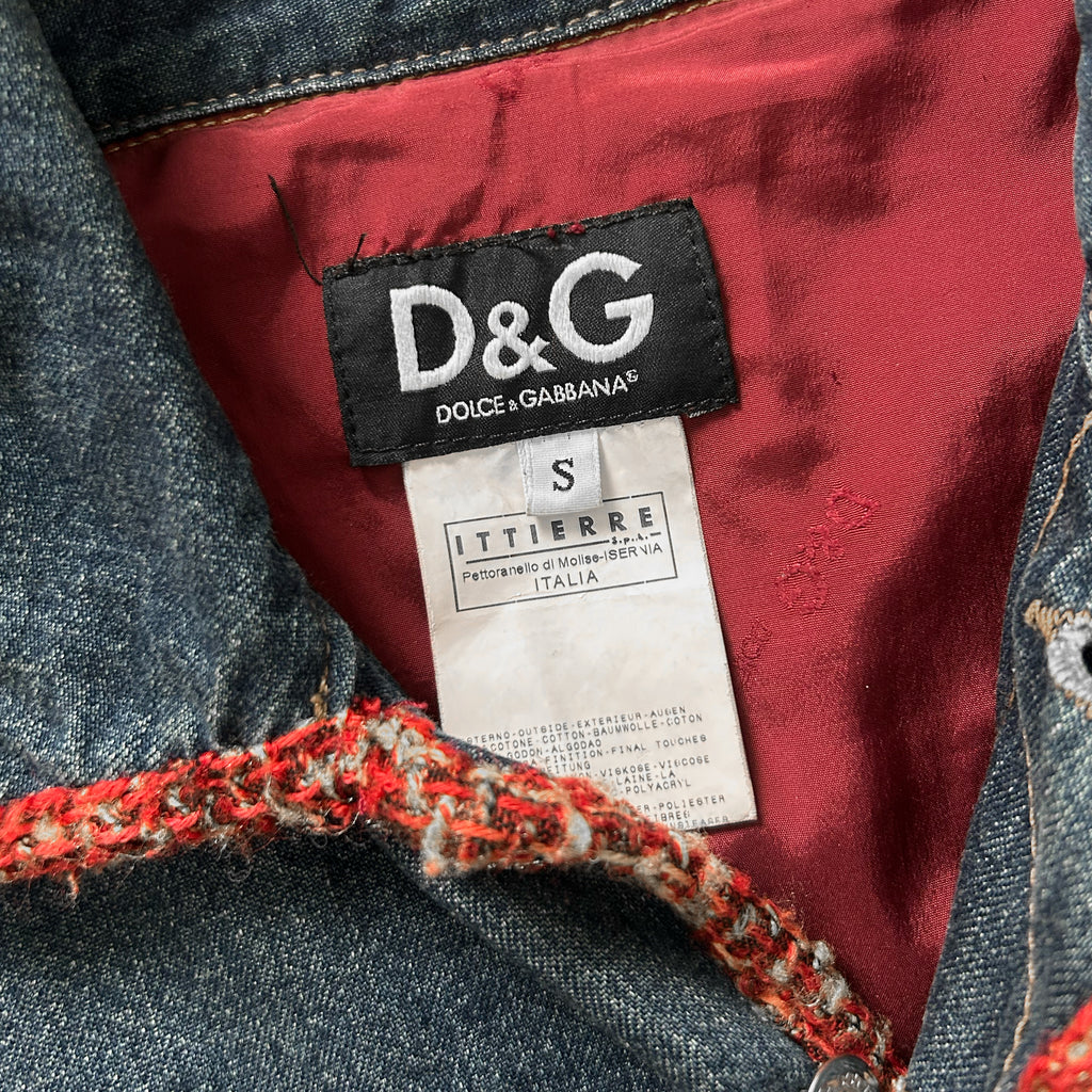 a close-up view of a denim jacket with a red lining and a black label on the collar.