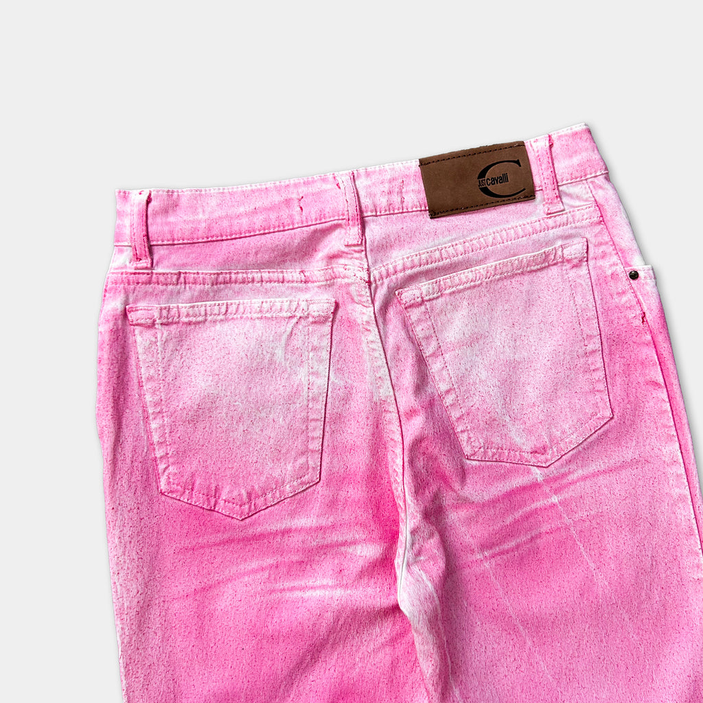 A pair of pink denim jeans with a brown leather patch on the back pocket.