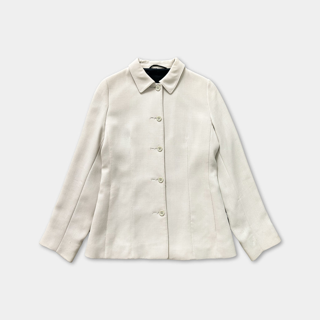 A cream-colored blazer with a button-down front and long sleeves, displayed against a white background.