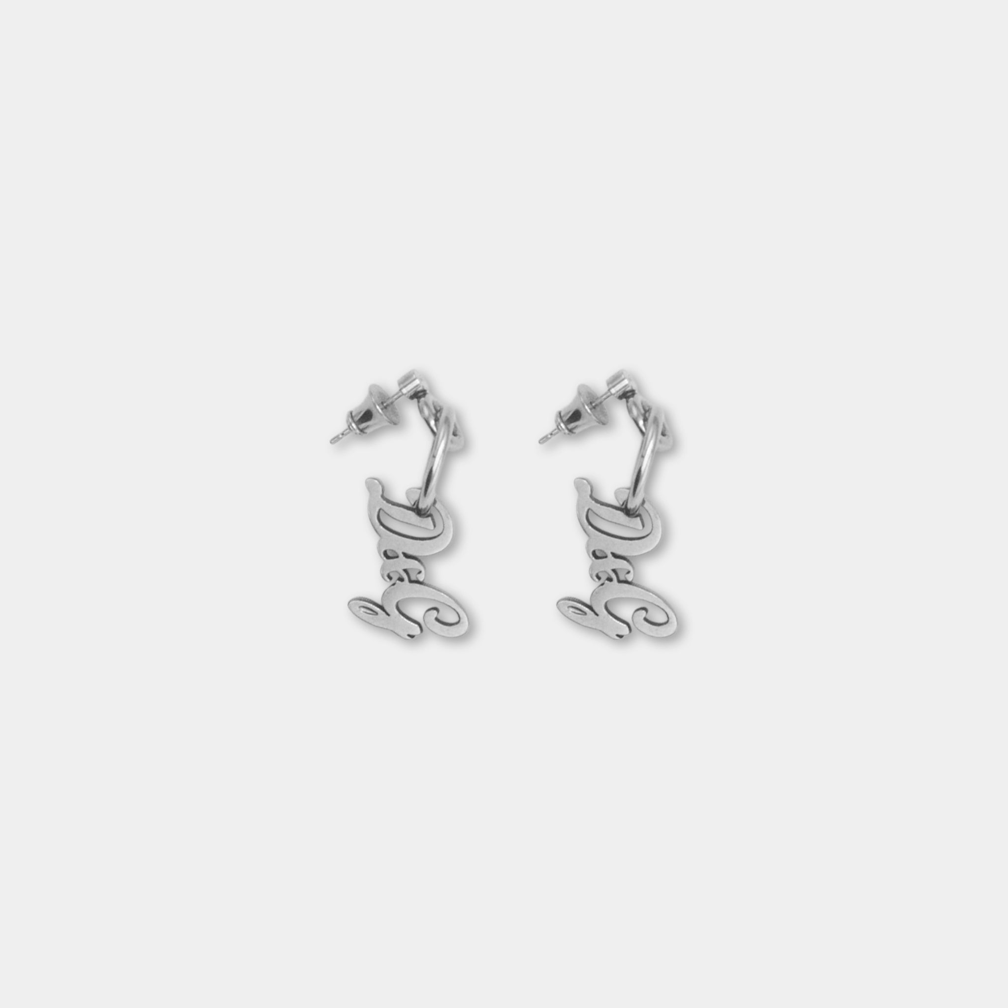 A pair of silver earrings with the word "D" engraved on them.