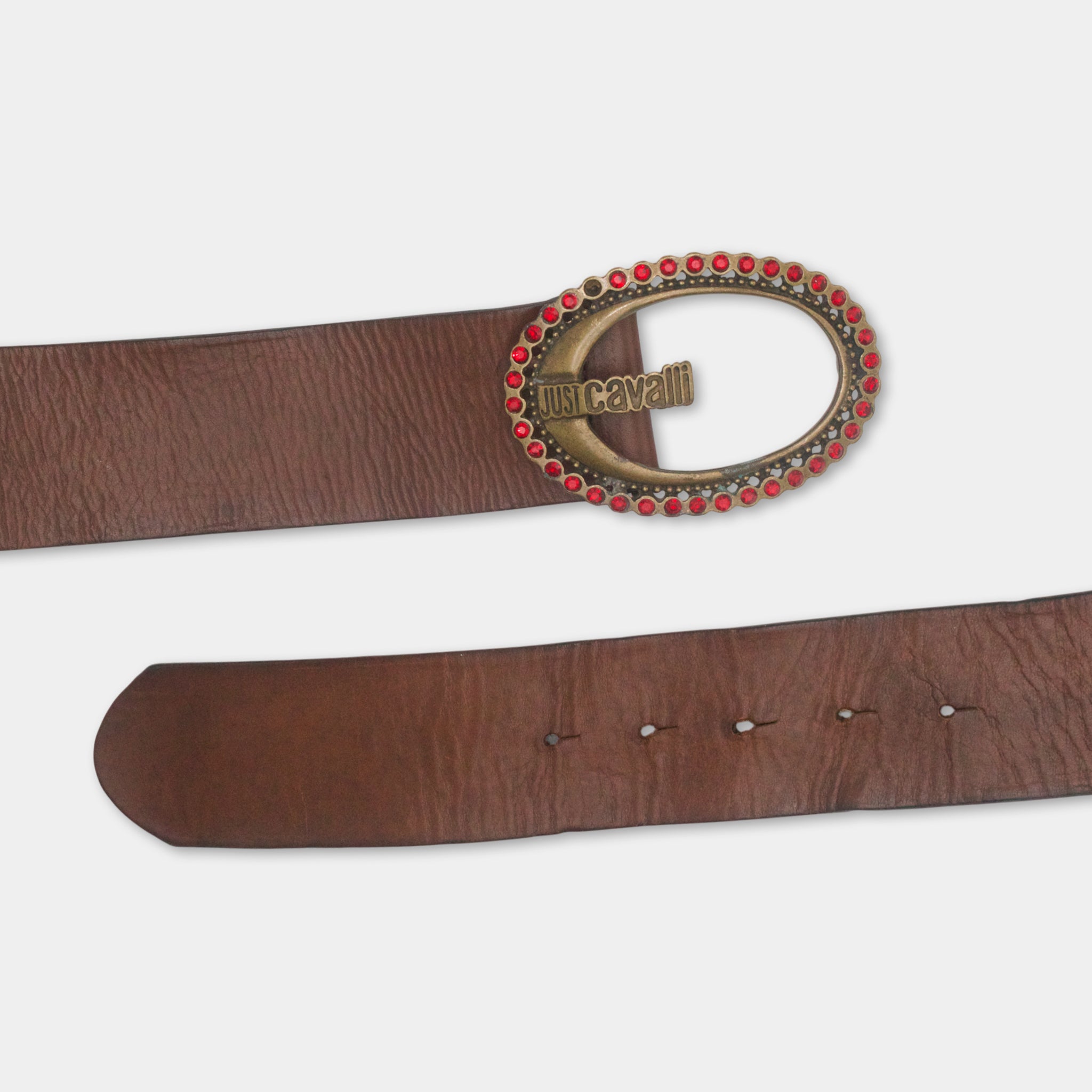 A brown leather belt with a decorative metal buckle featuring red gemstones.