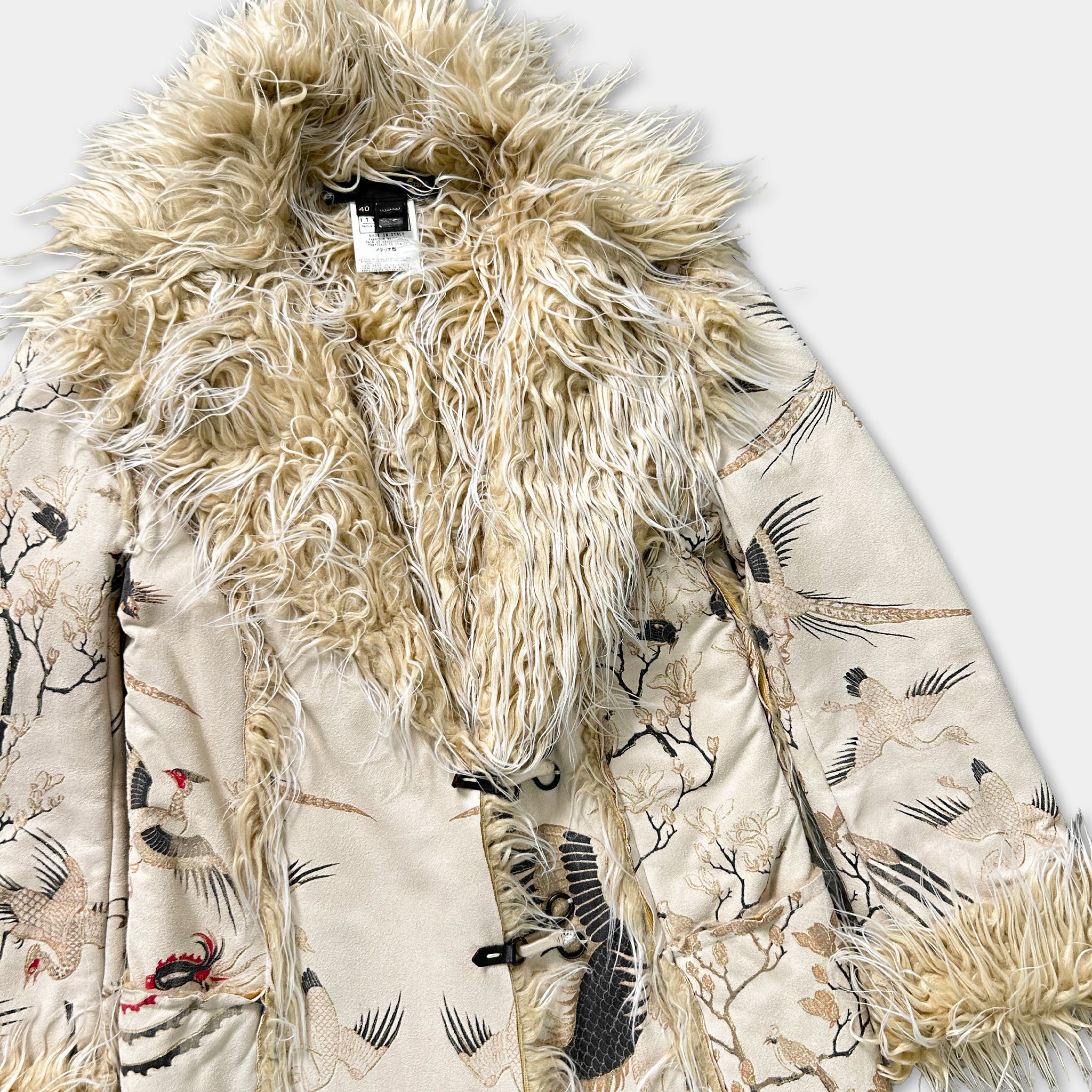 A beige fur coat with a floral pattern and a fluffy collar.