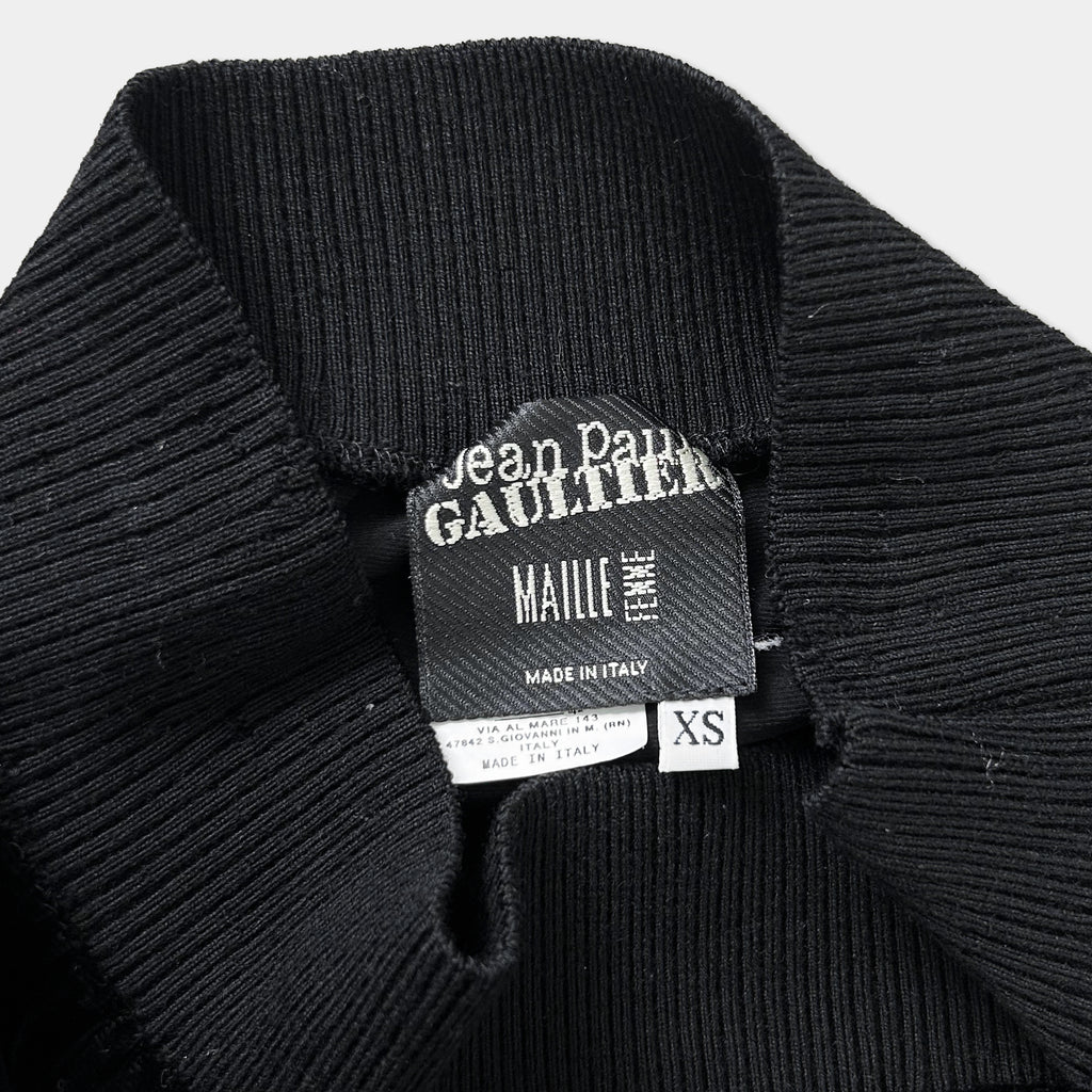a close-up view of a black sweater or garment with a label attached to it.