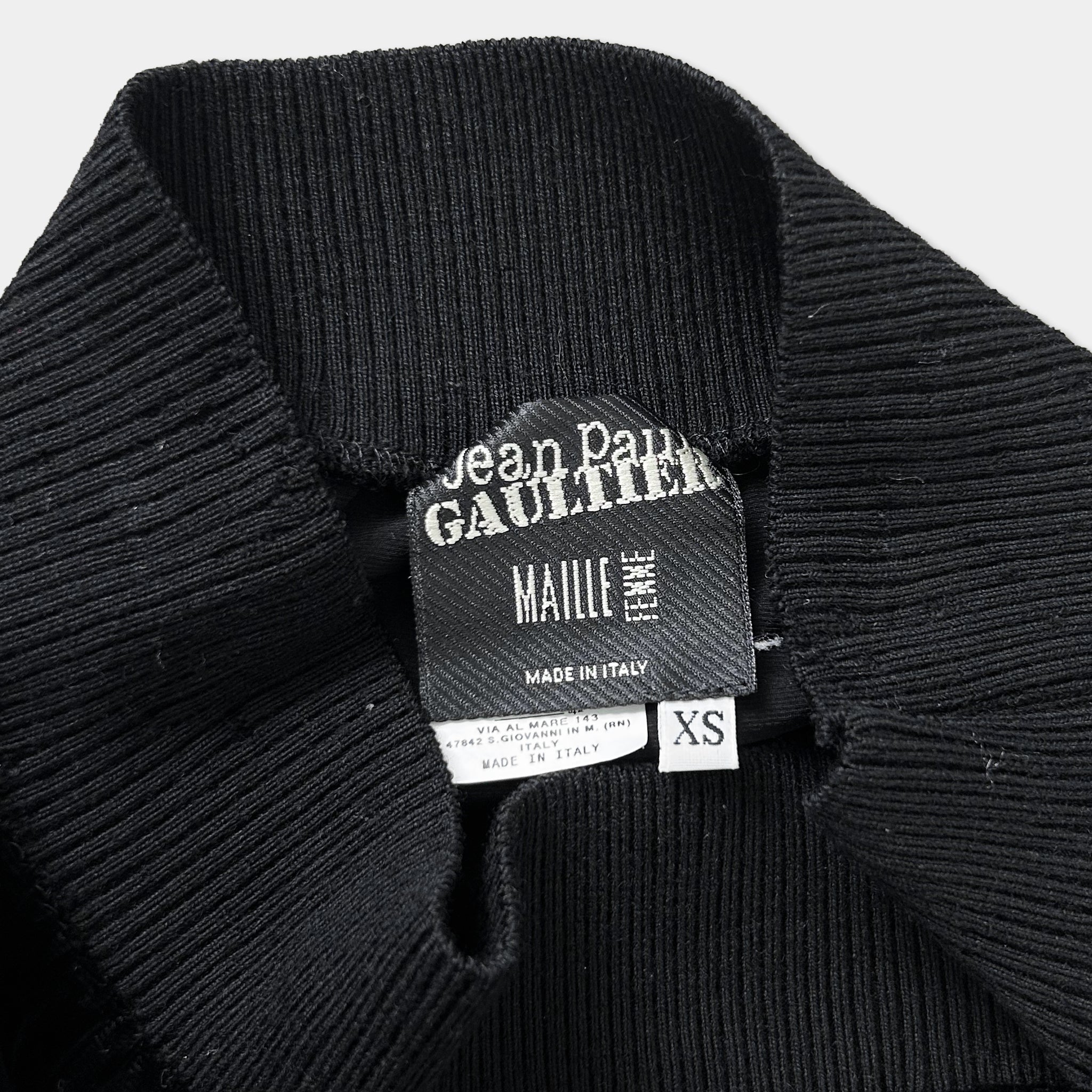 a close-up view of a black sweater or garment with a label attached to it.