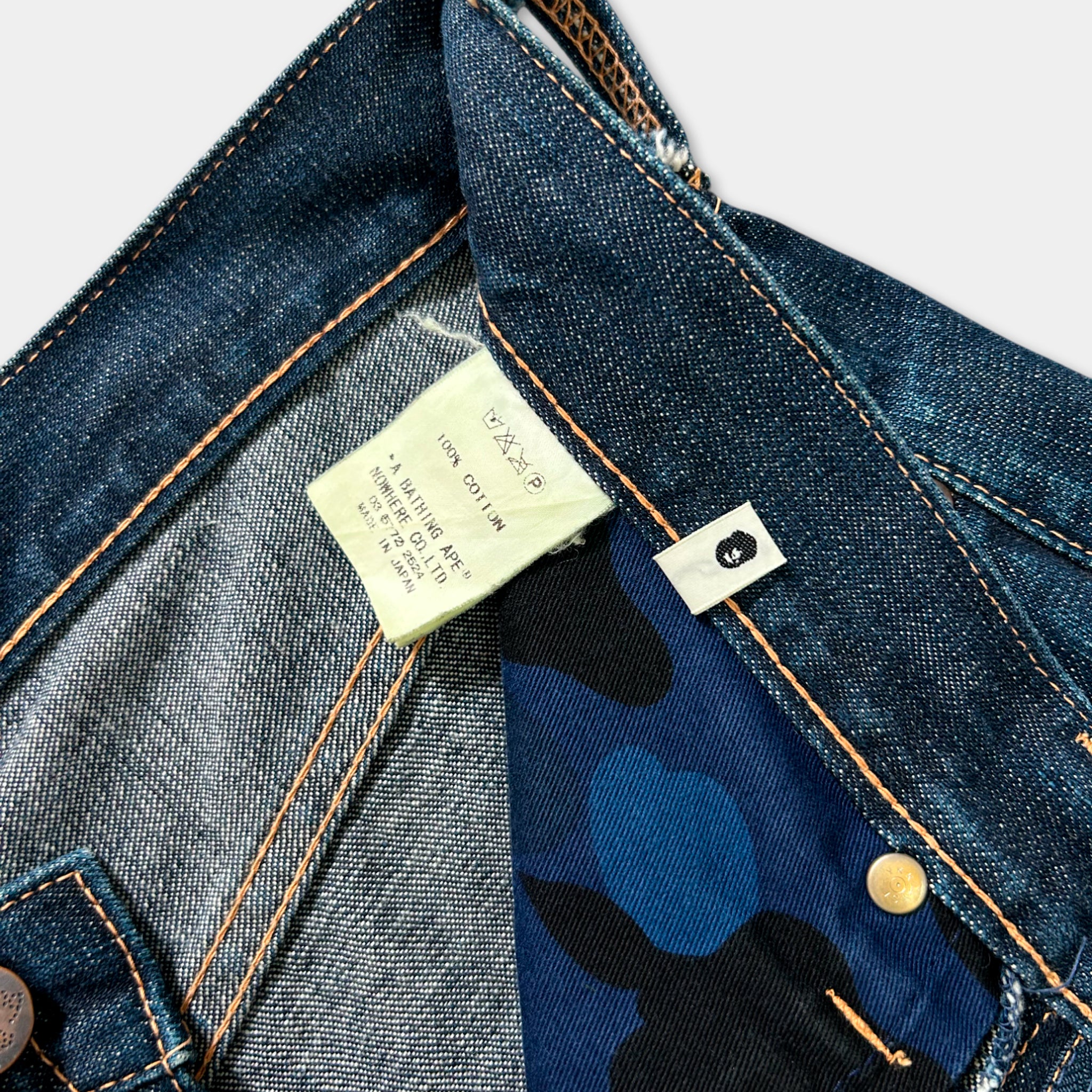 a close-up view of a pair of blue jeans with a label attached to the pocket.