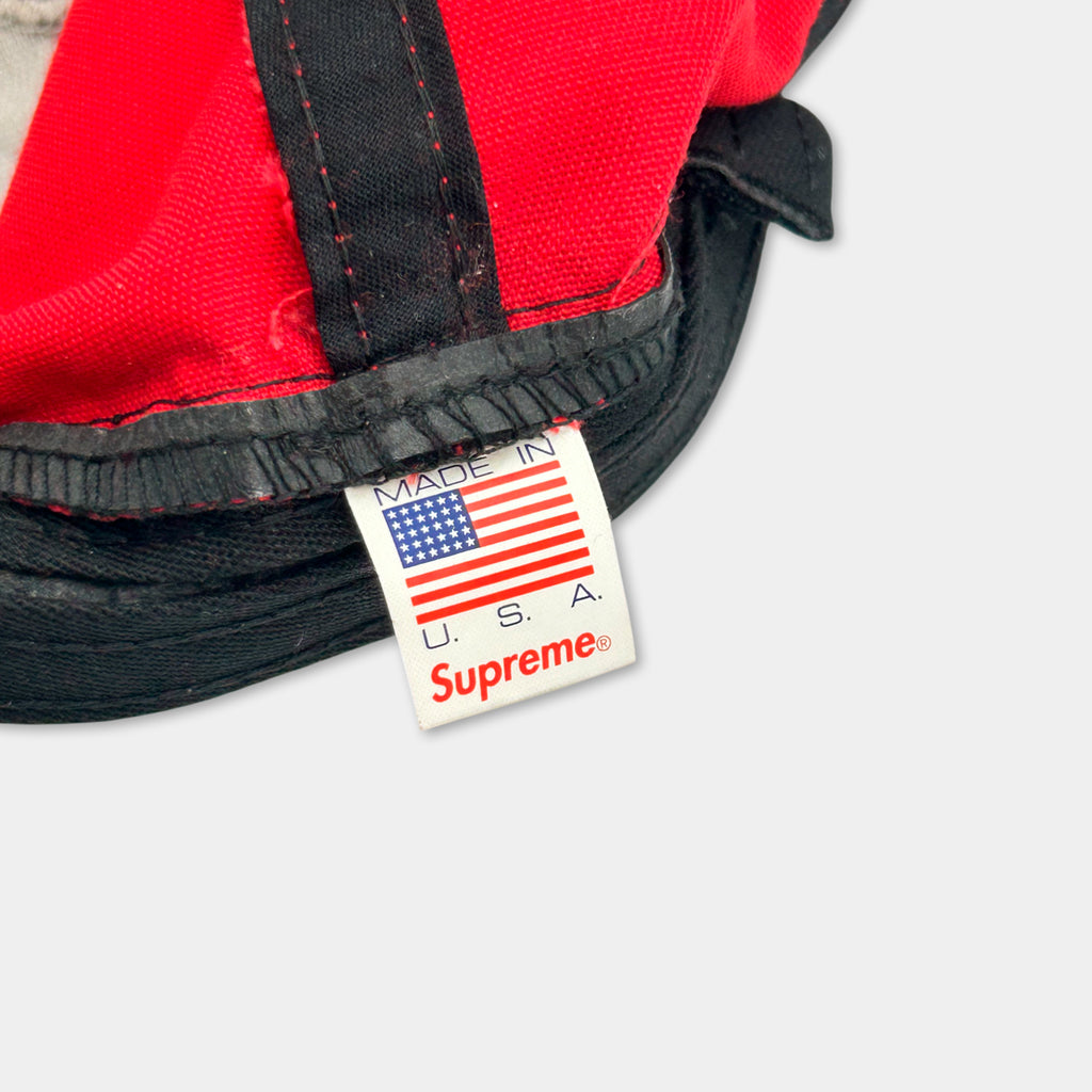 A close-up view of a red and black baseball cap with a label that reads "Made in U.S.A."