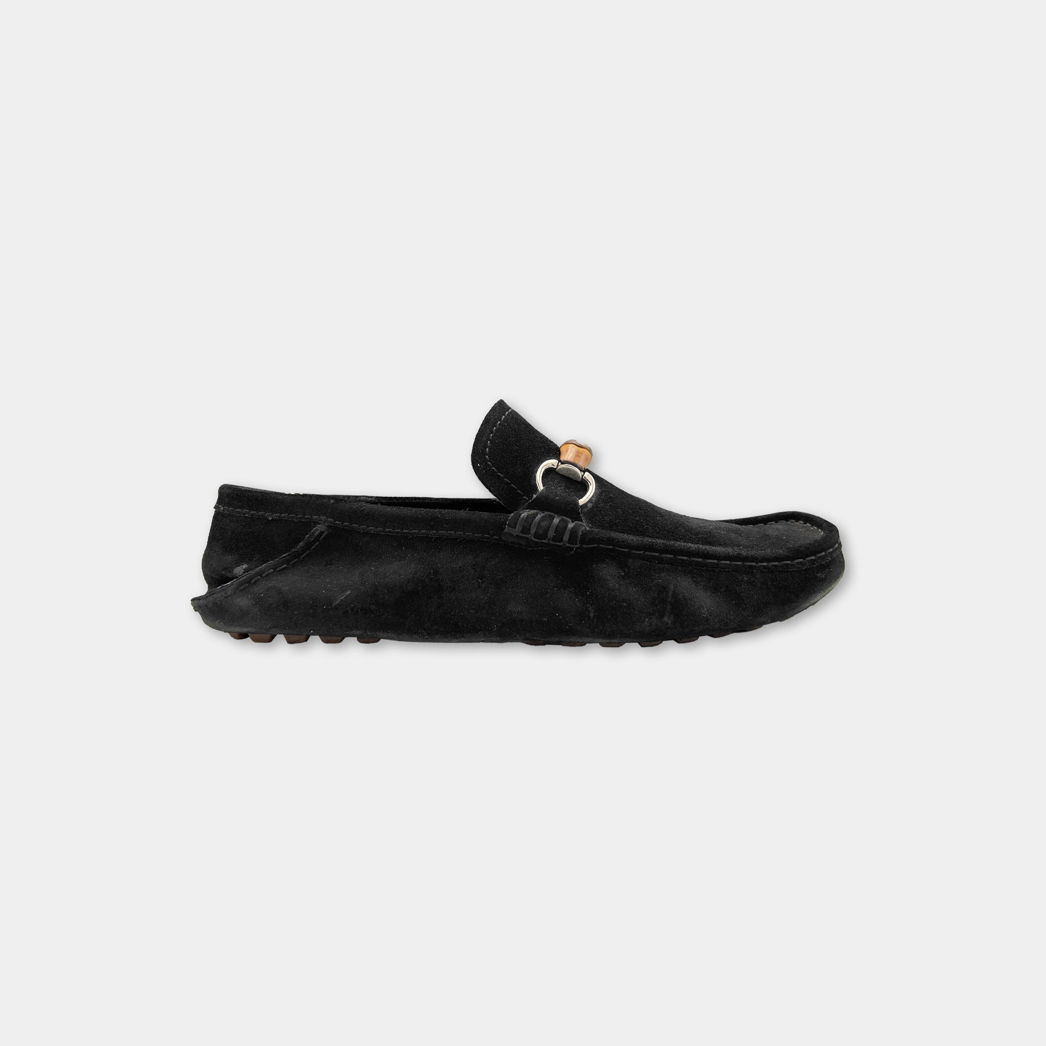 A black leather loafers with a buckle detail on the toe.