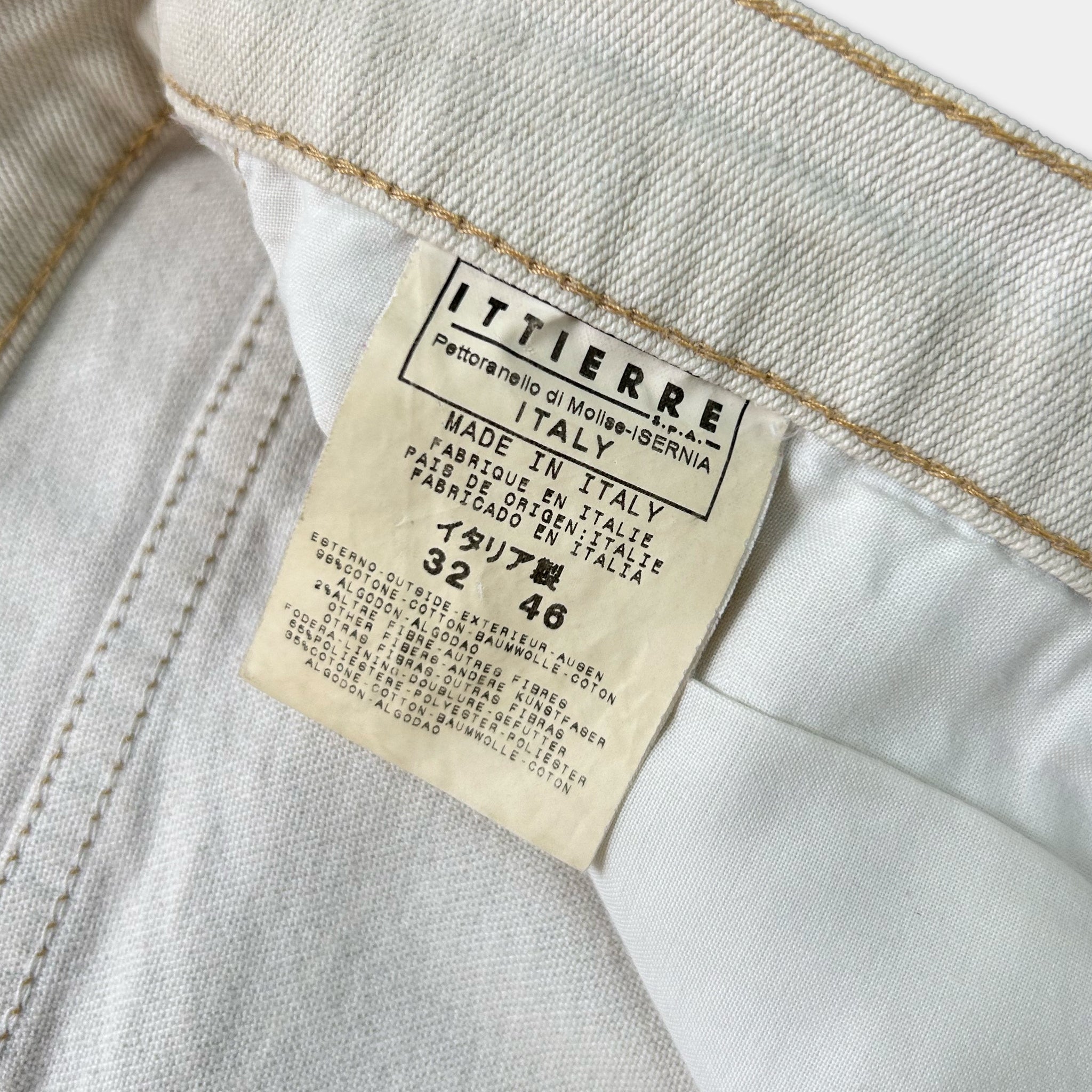 a close-up view of a label on a pair of white jeans, indicating that they are made in Italy.