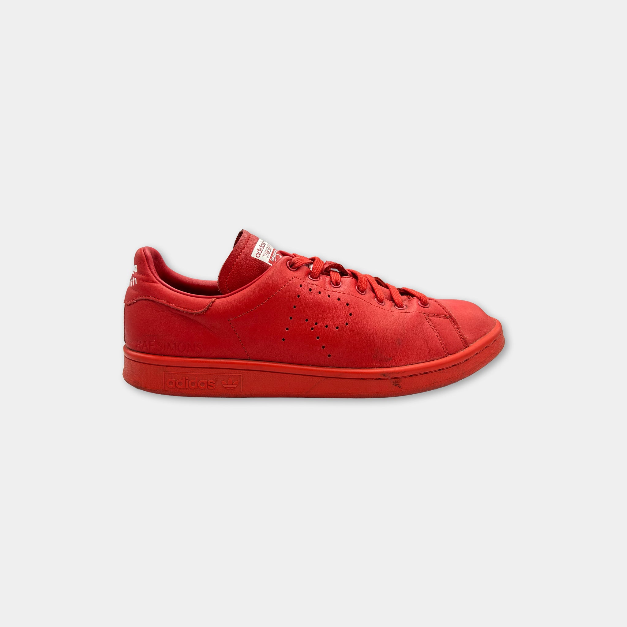 A red Adidas sneaker with a white logo on the side.