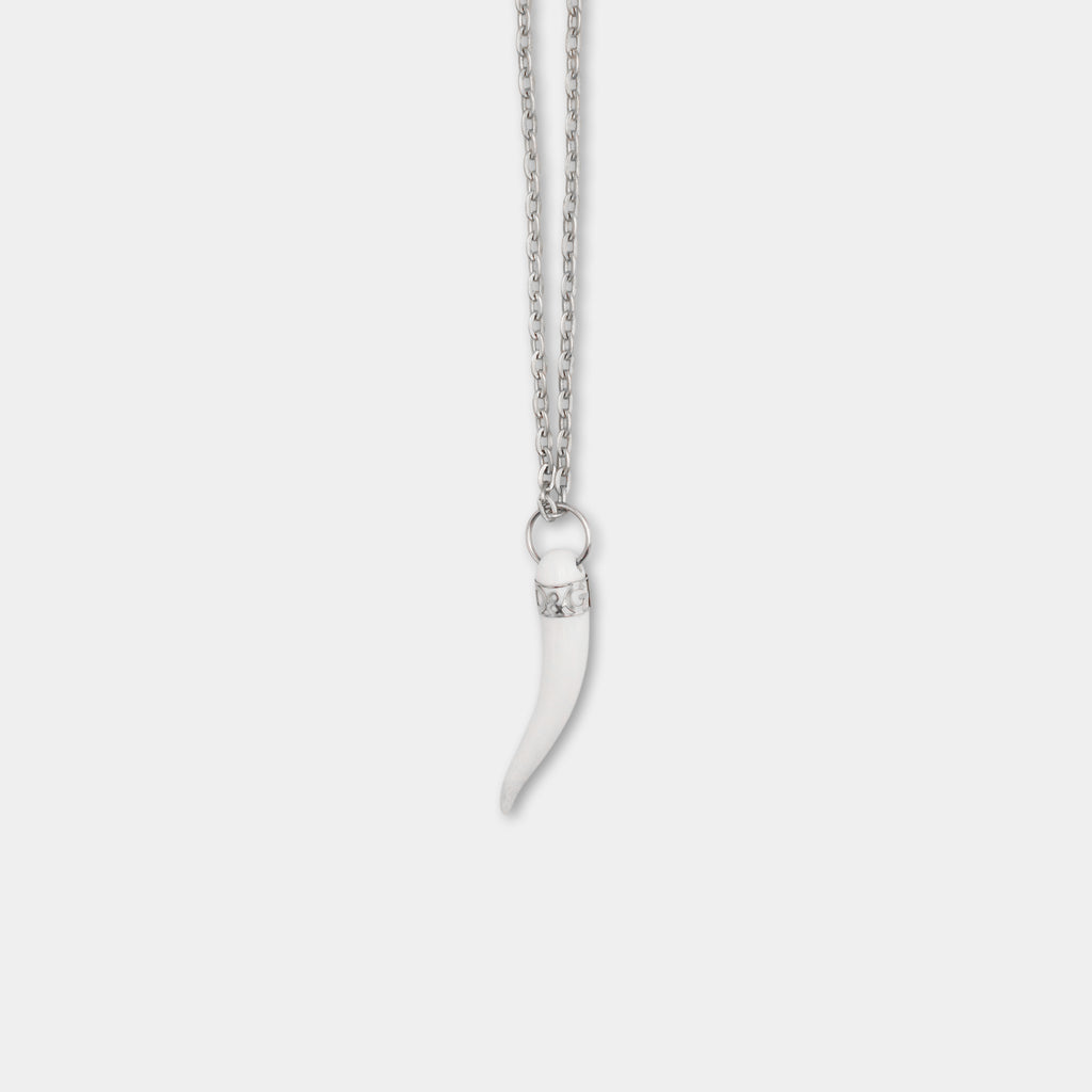 A silver necklace with a pendant featuring a white horn-like shape.