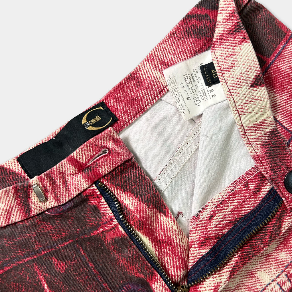 a close-up view of a pair of red and white patterned pants with a label attached to the waistband.