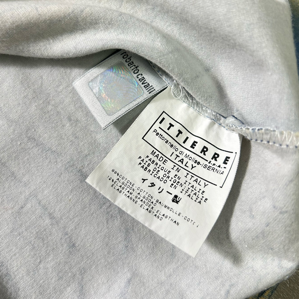 a close-up view of a white fabric, possibly a garment or textile, with a label attached to it. The label appears to be a product label or tag, providing information about the item.