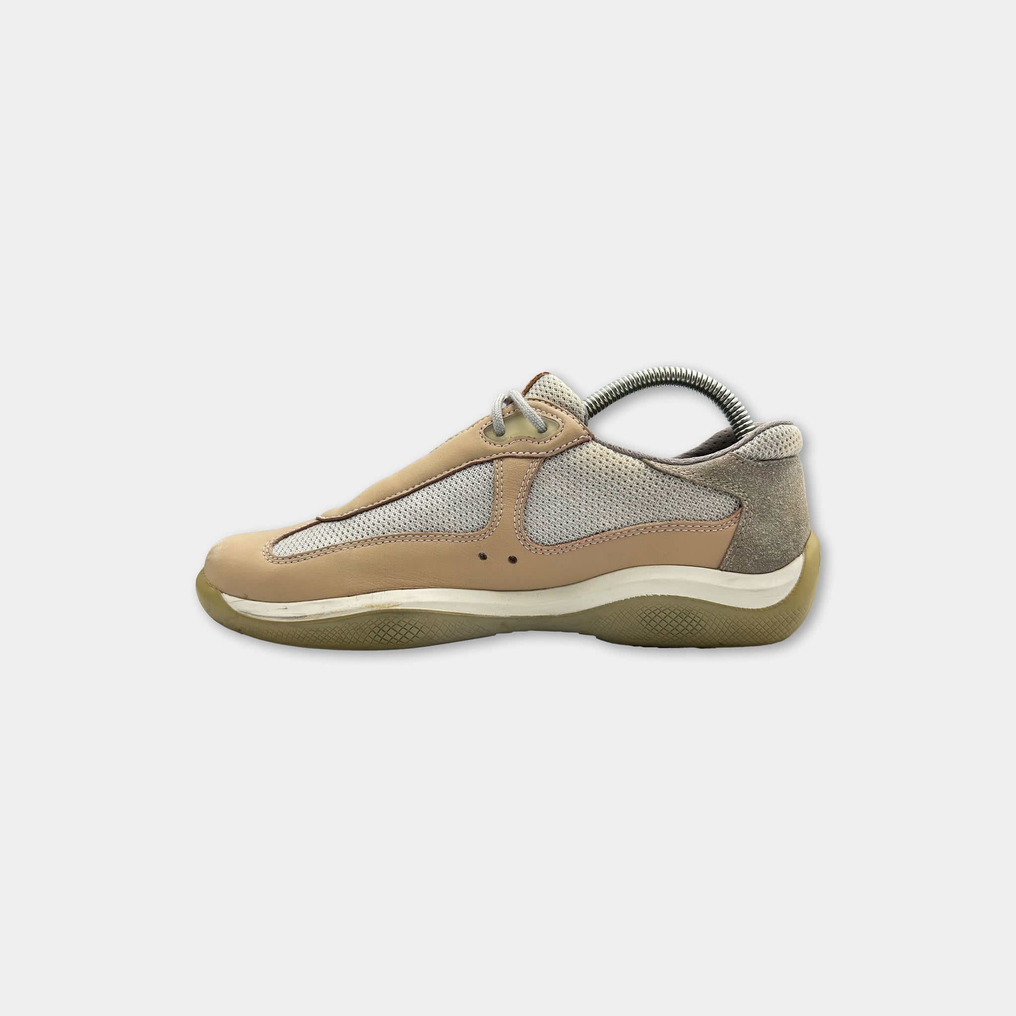 A tan and gray sneaker with a mesh panel on the side.