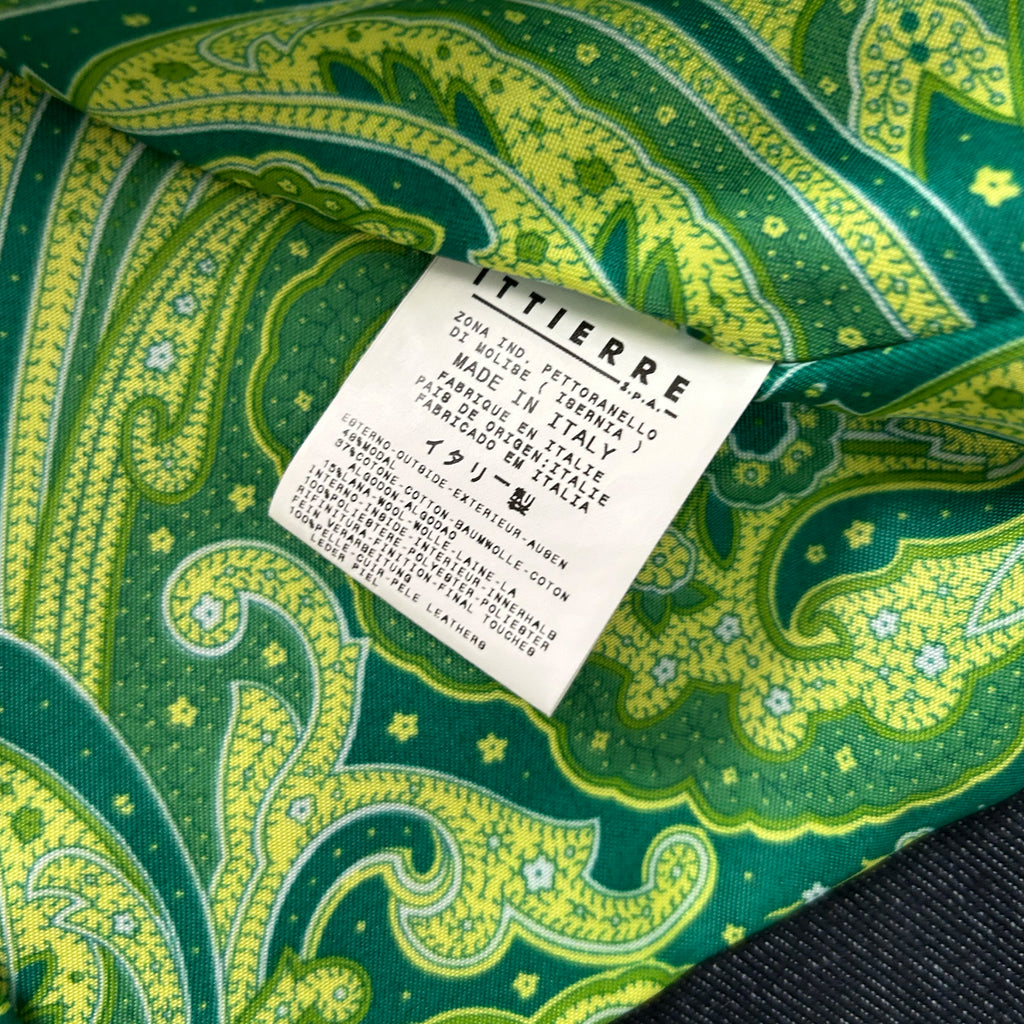 a close-up view of a fabric label with a paisley pattern in shades of green and yellow.