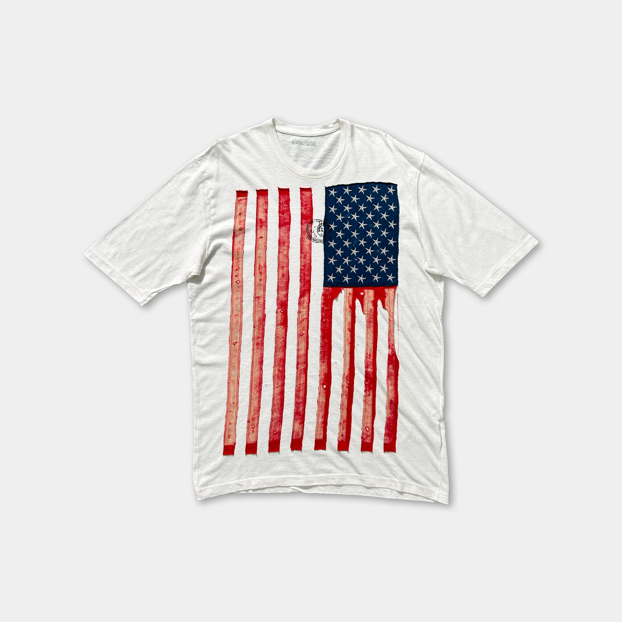 A white t-shirt with a graphic design of the American flag printed on it.
