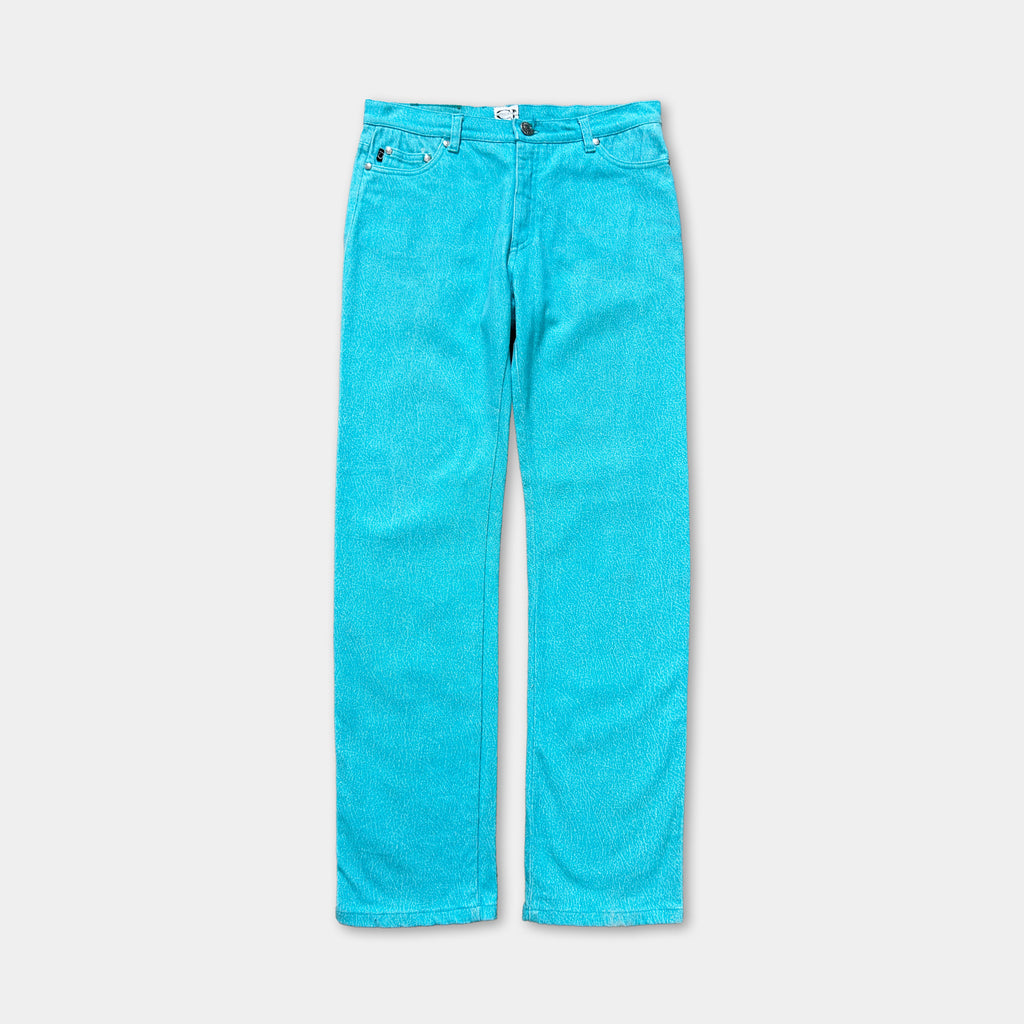 A pair of bright turquoise-colored jeans against a plain background.