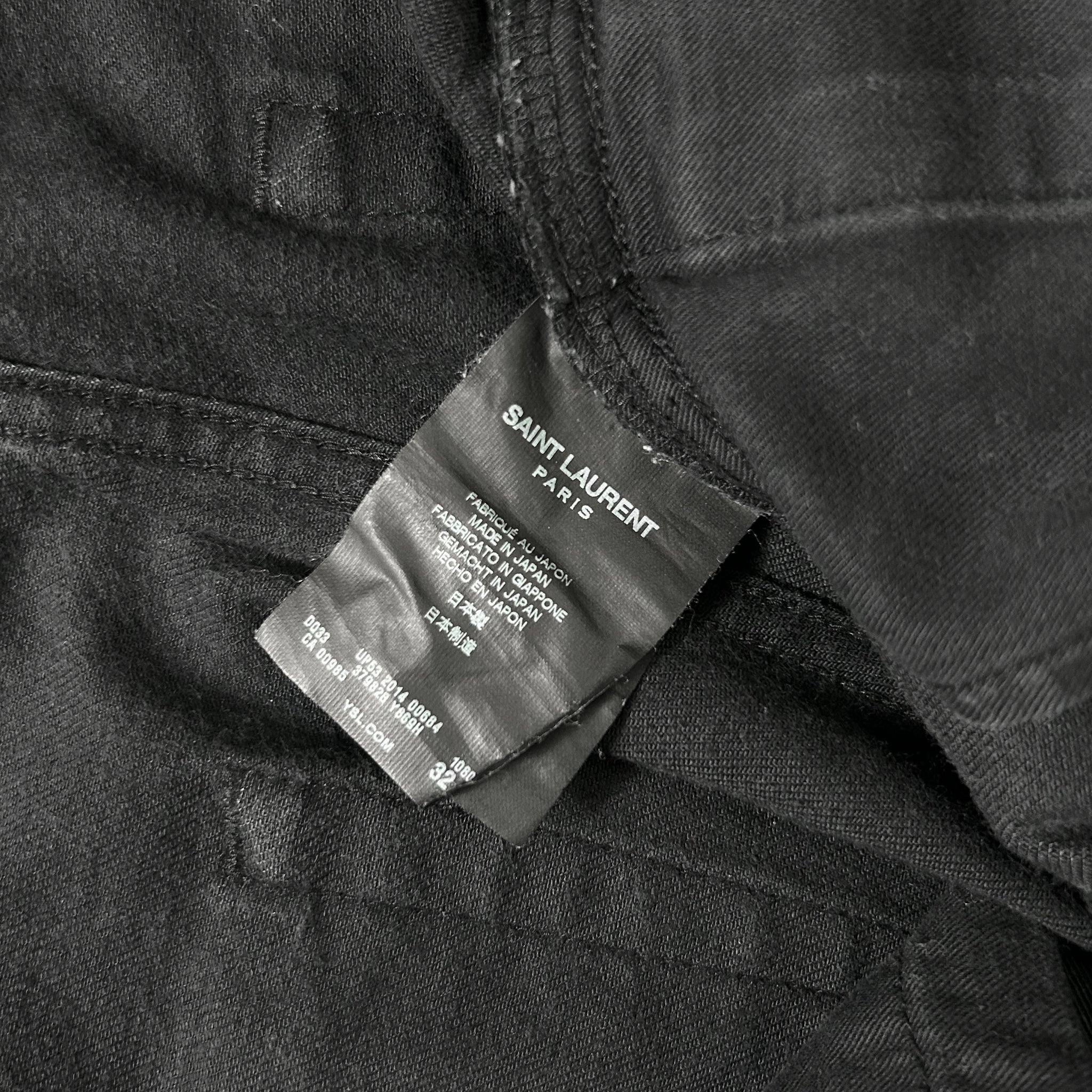 A close-up view of a black fabric, possibly a piece of clothing, with a label attached to it. The label appears to be a label from a clothing brand, specifically Saint Laurent.