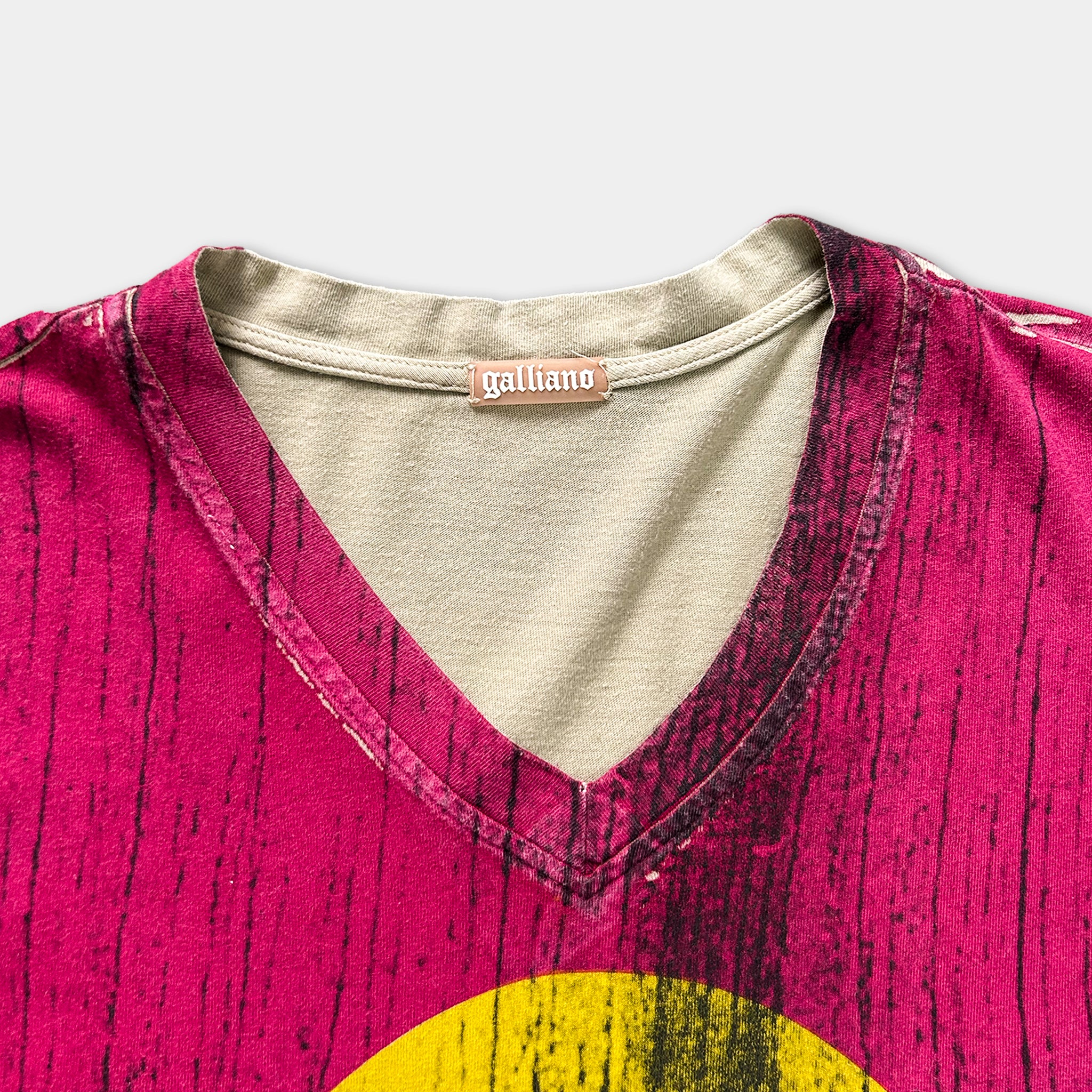 a close-up view of a pink and yellow patterned shirt with a collar and a label on the collar.