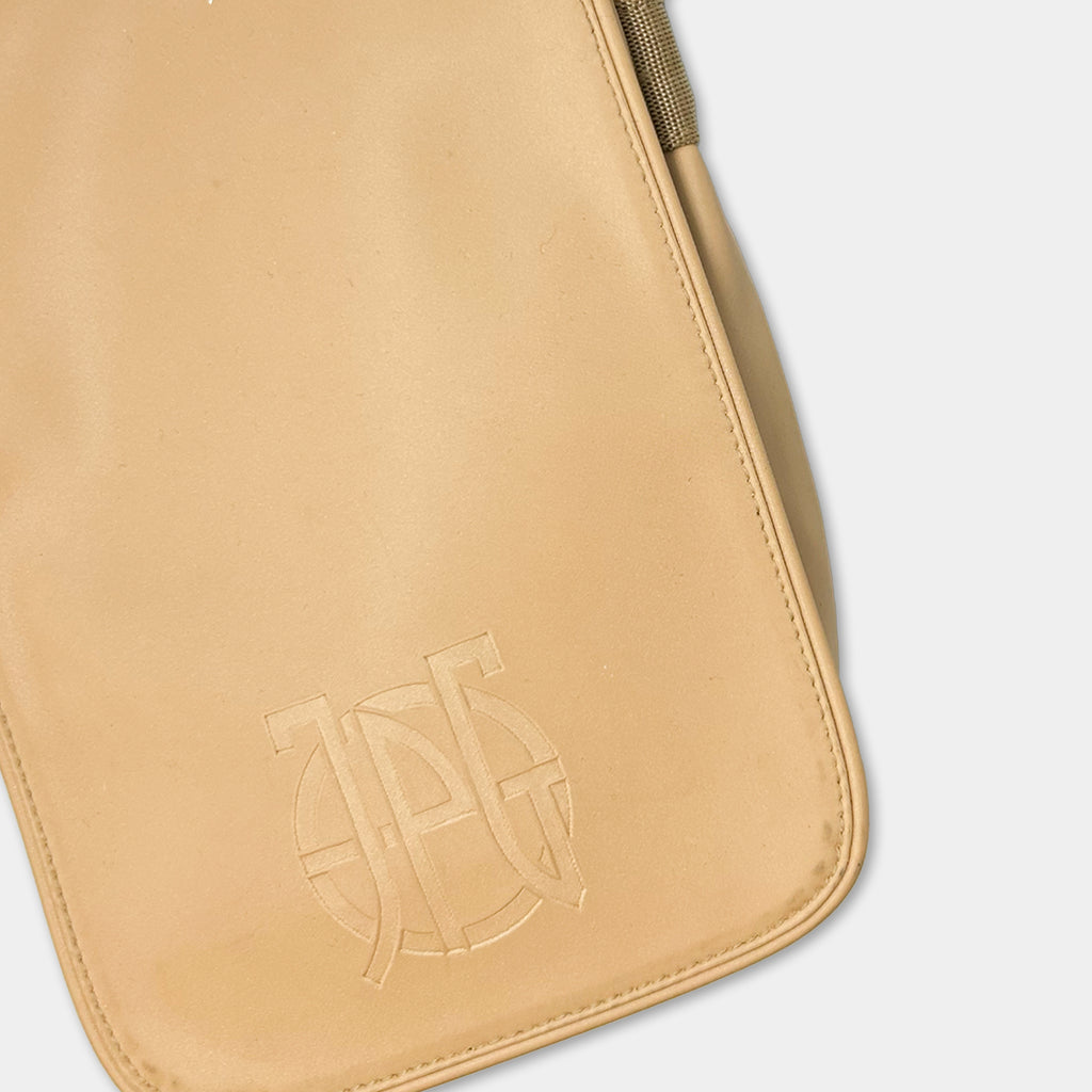 A tan-colored leather bag with a logo embossed on it.