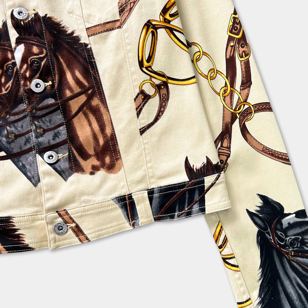 a close-up view of a jacket with a printed design of horses and leather straps.