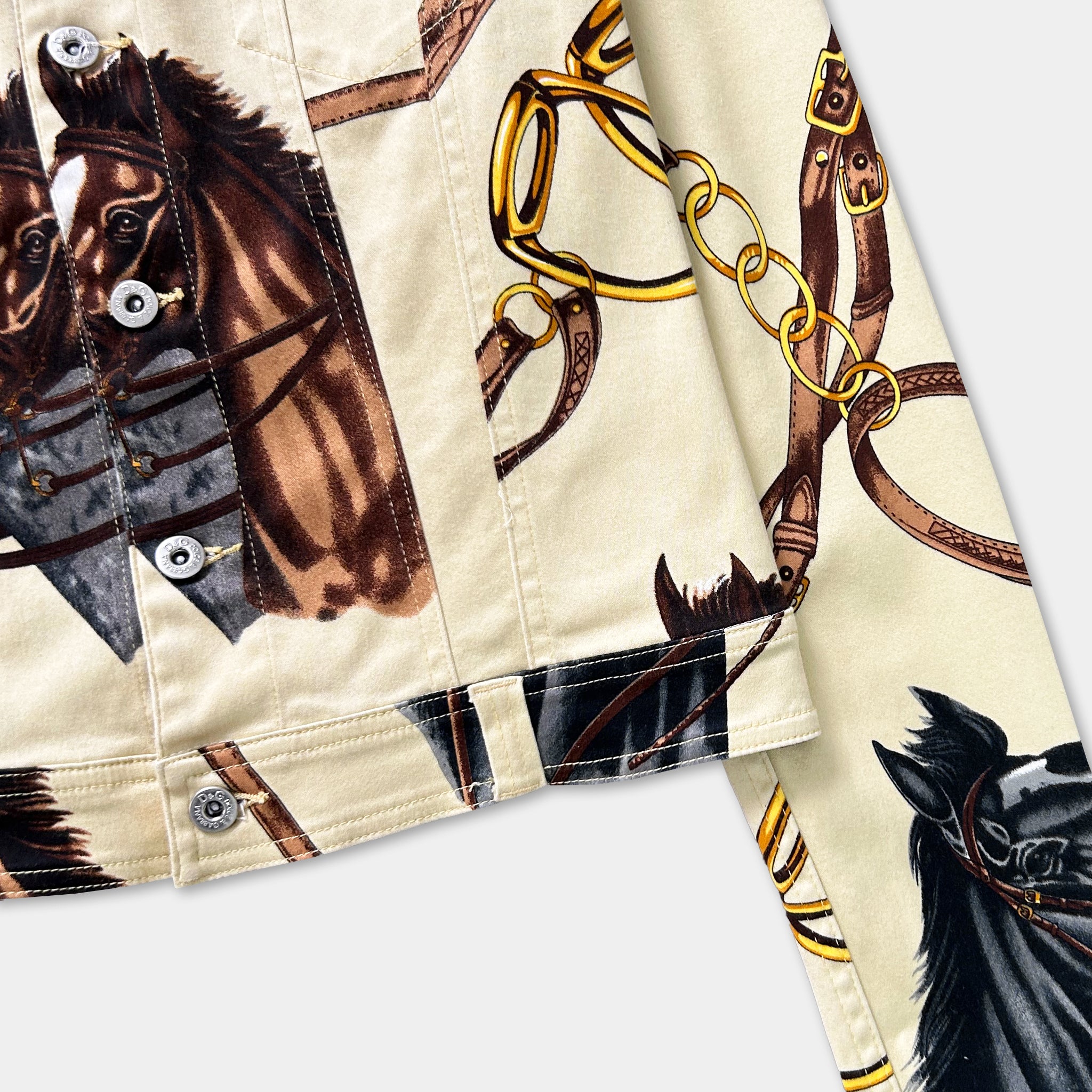 a close-up view of a jacket with a printed design of horses and leather straps.