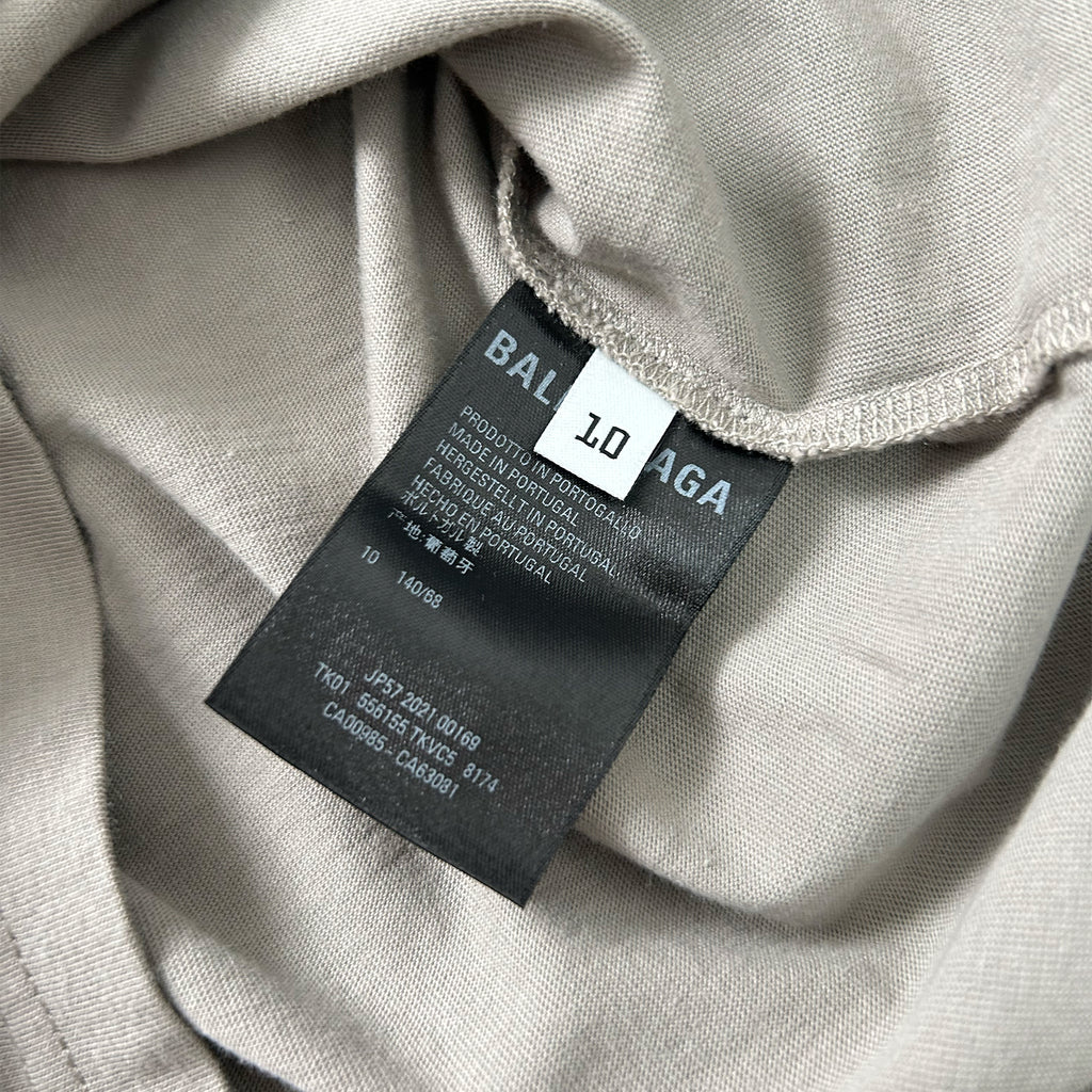 A close-up view of a grey fabric with a black label attached to it, displaying text and numbers.