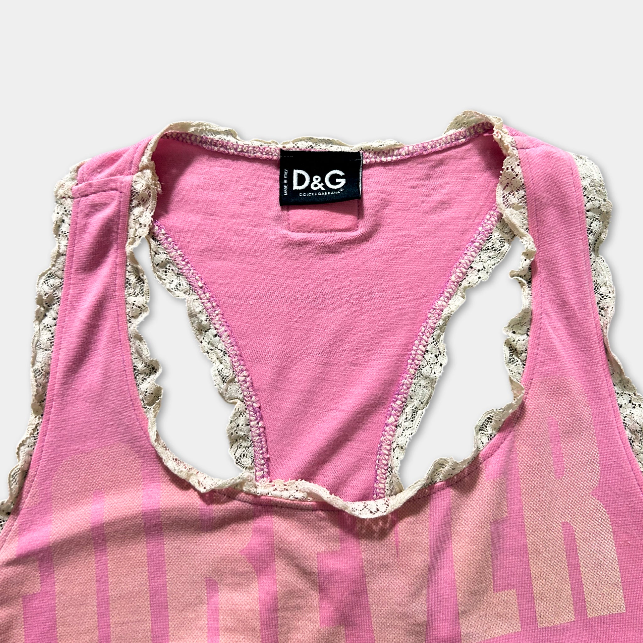 A pink tank top with lace trim and a D&G logo on the neckline.