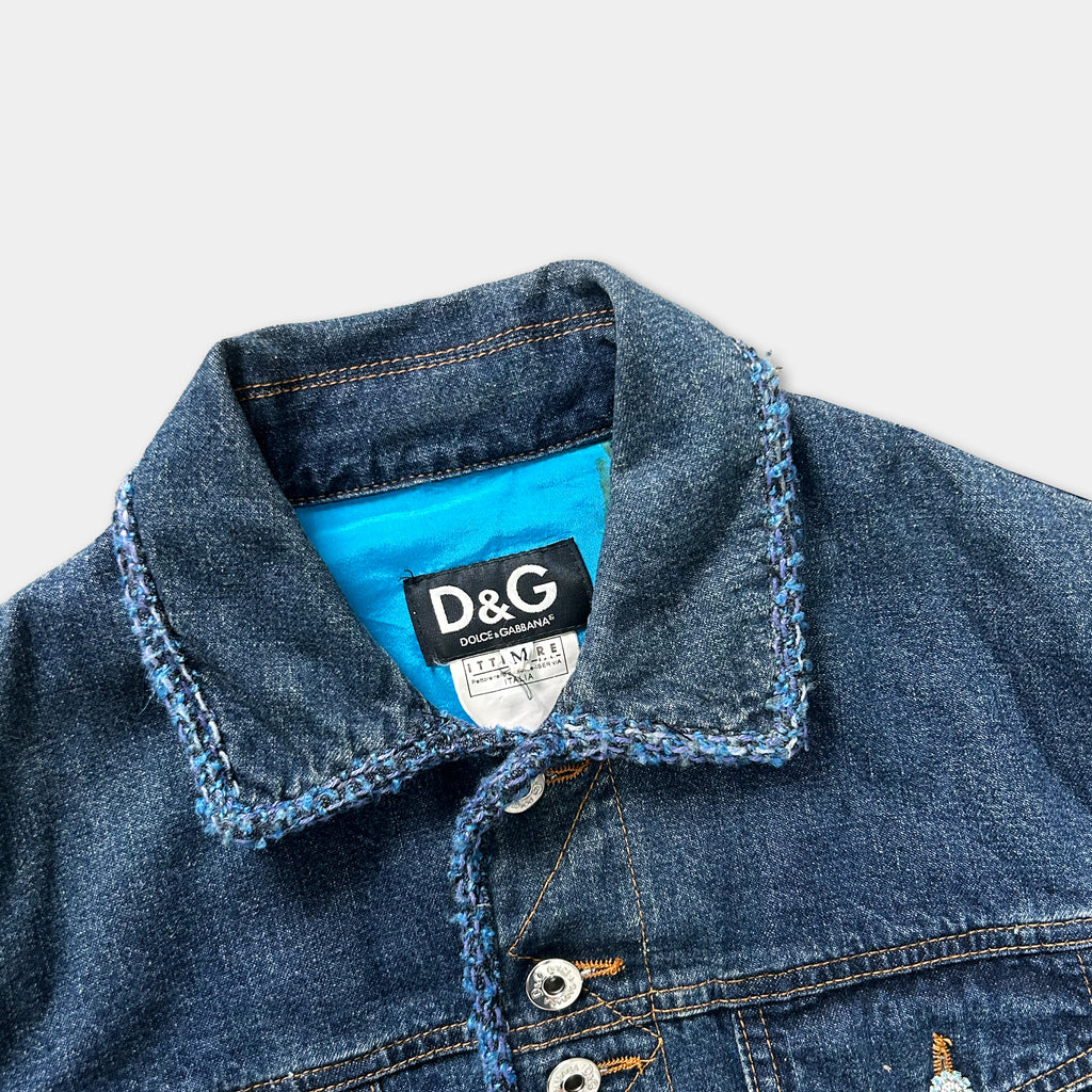 A close-up view of a denim jacket with a blue collar and a label on the collar.