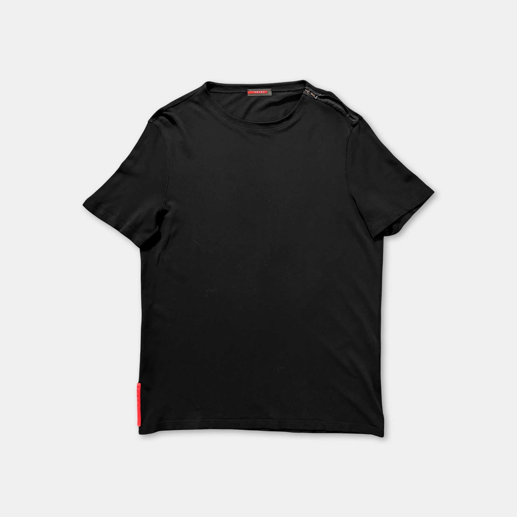 A black t-shirt with a red tag on the left side.