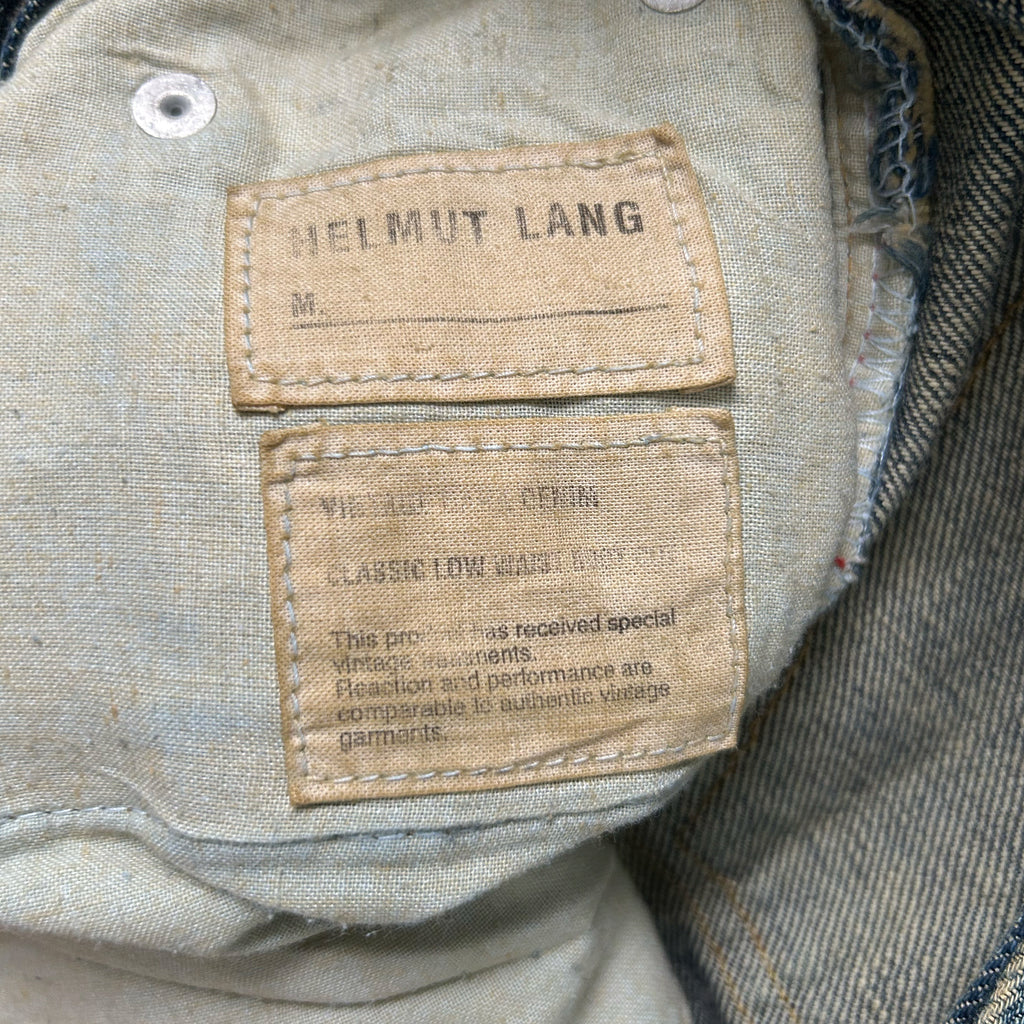 a close-up view of a fabric label on a pair of jeans, with a focus on the brand name "Helmut Lang" and the tag indicating the jeans are "Classics Low-Hanging Vintage Performance".