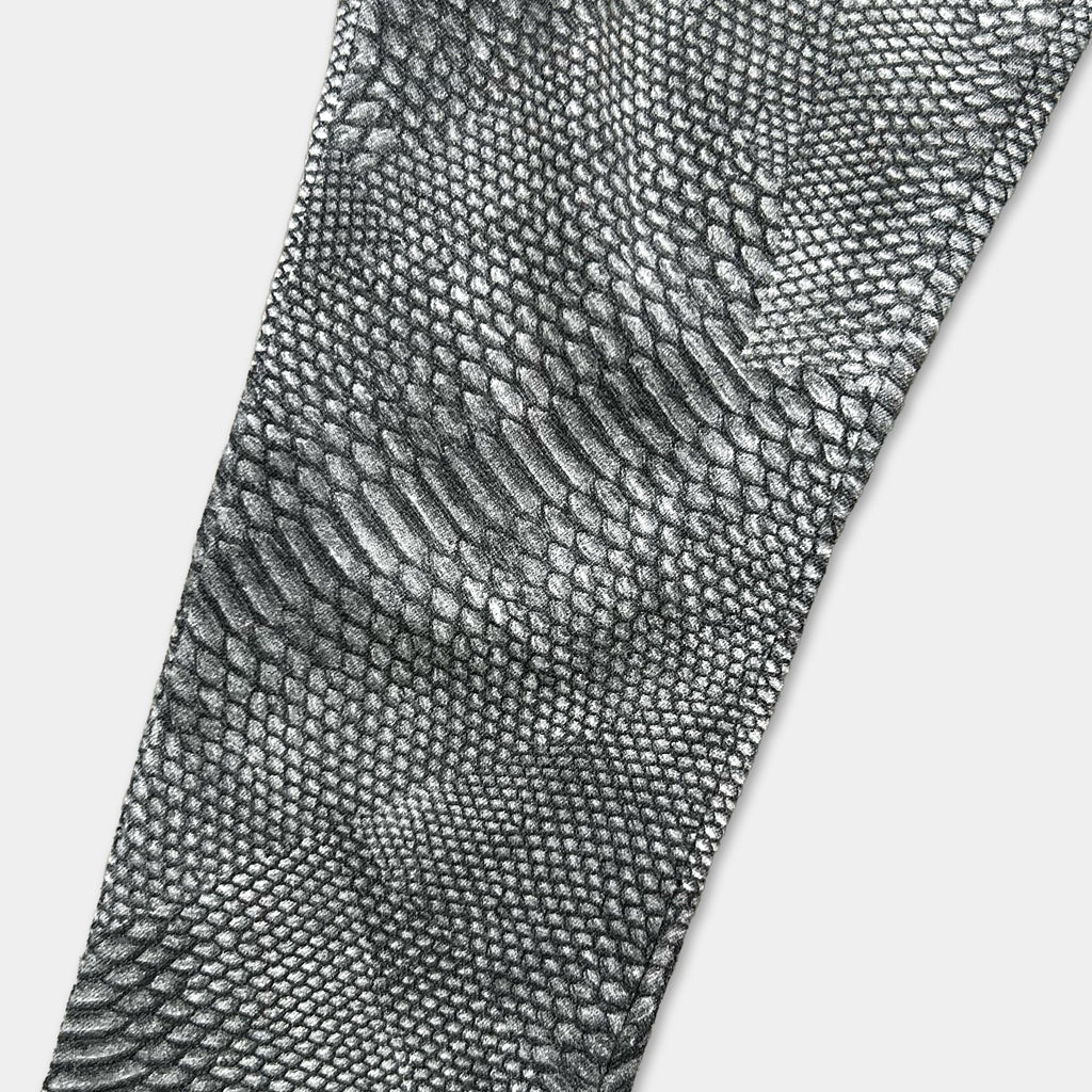 a close-up view of a pair of black and white patterned pants, featuring a distinctive snake skin texture.