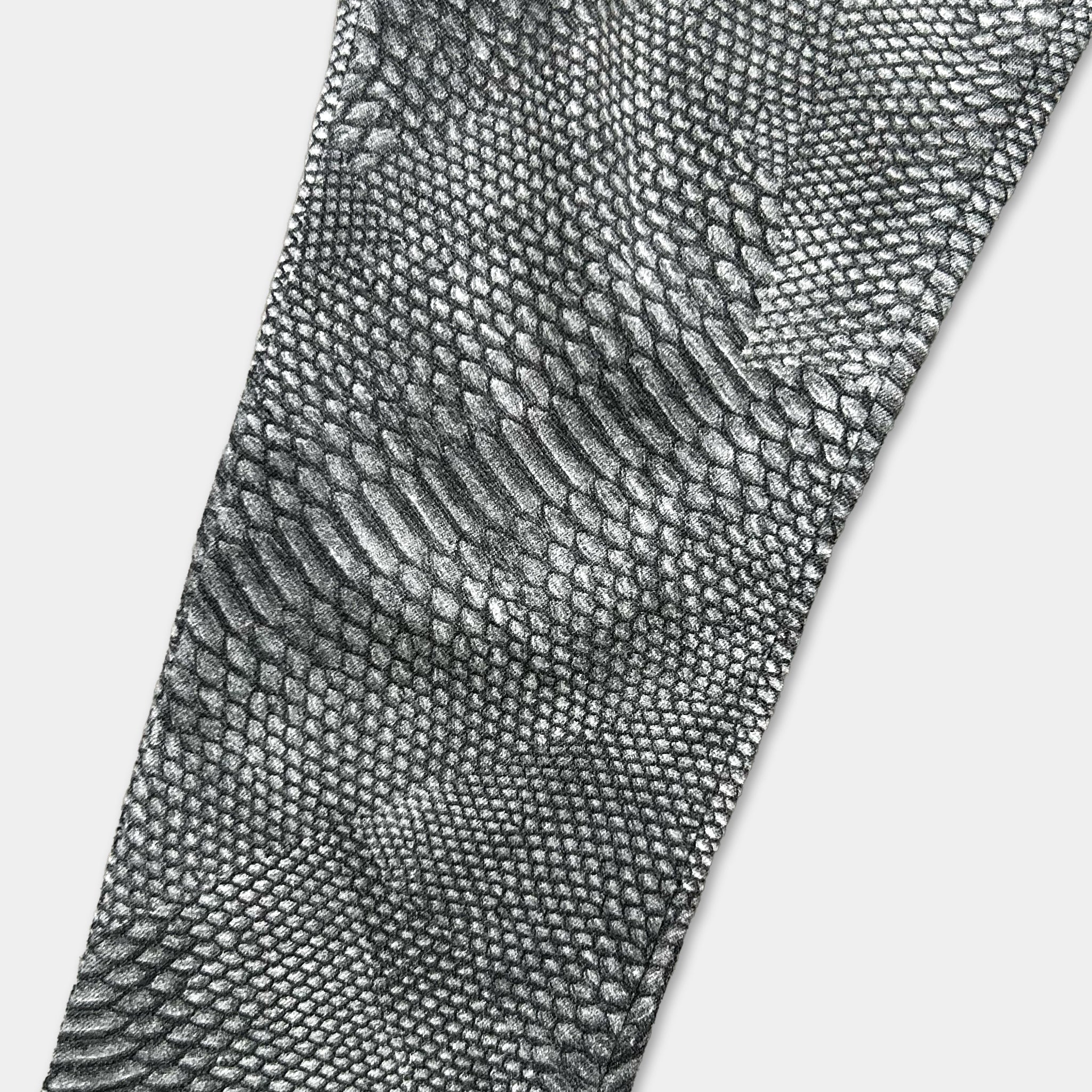 a close-up view of a pair of black and white patterned pants, featuring a distinctive snake skin texture.
