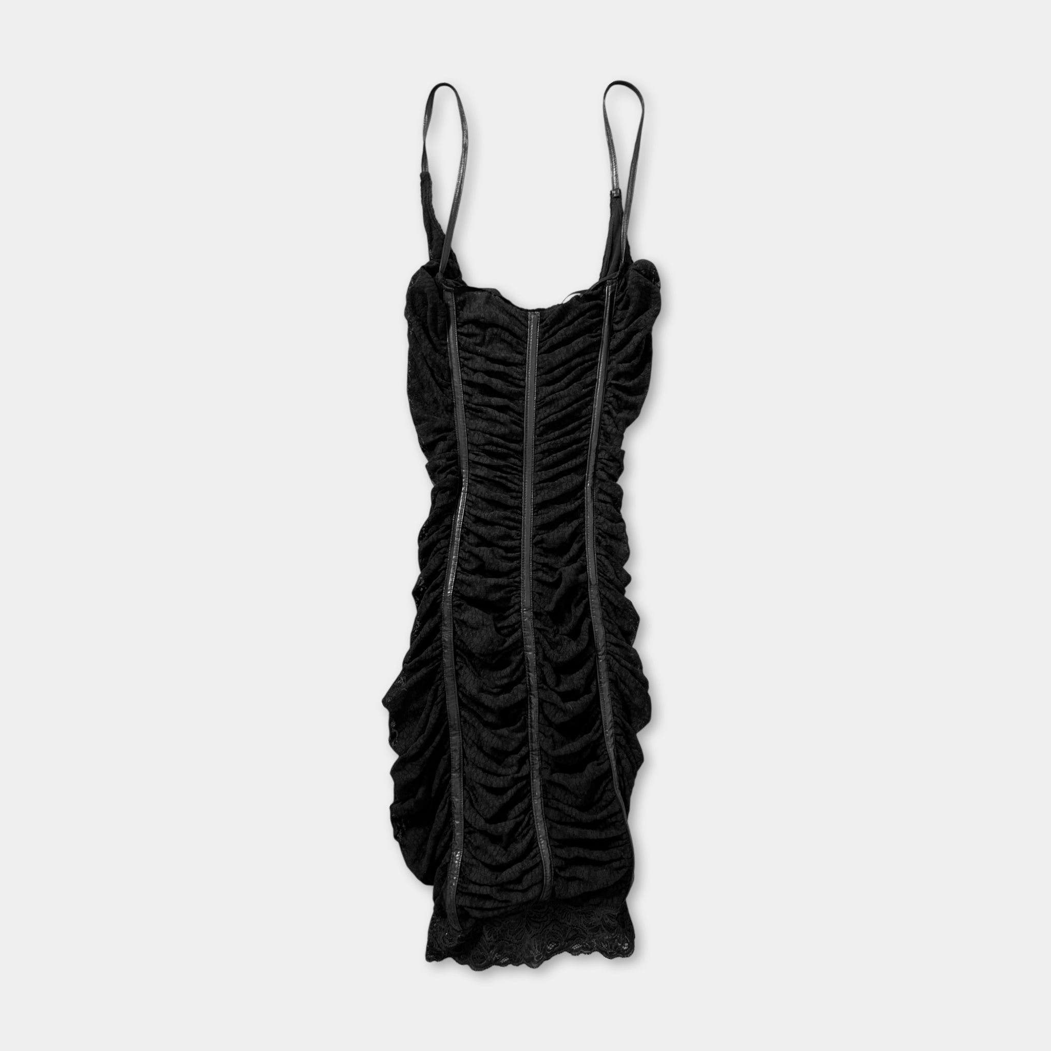 A black ruched dress with thin straps, displayed against a plain white background.