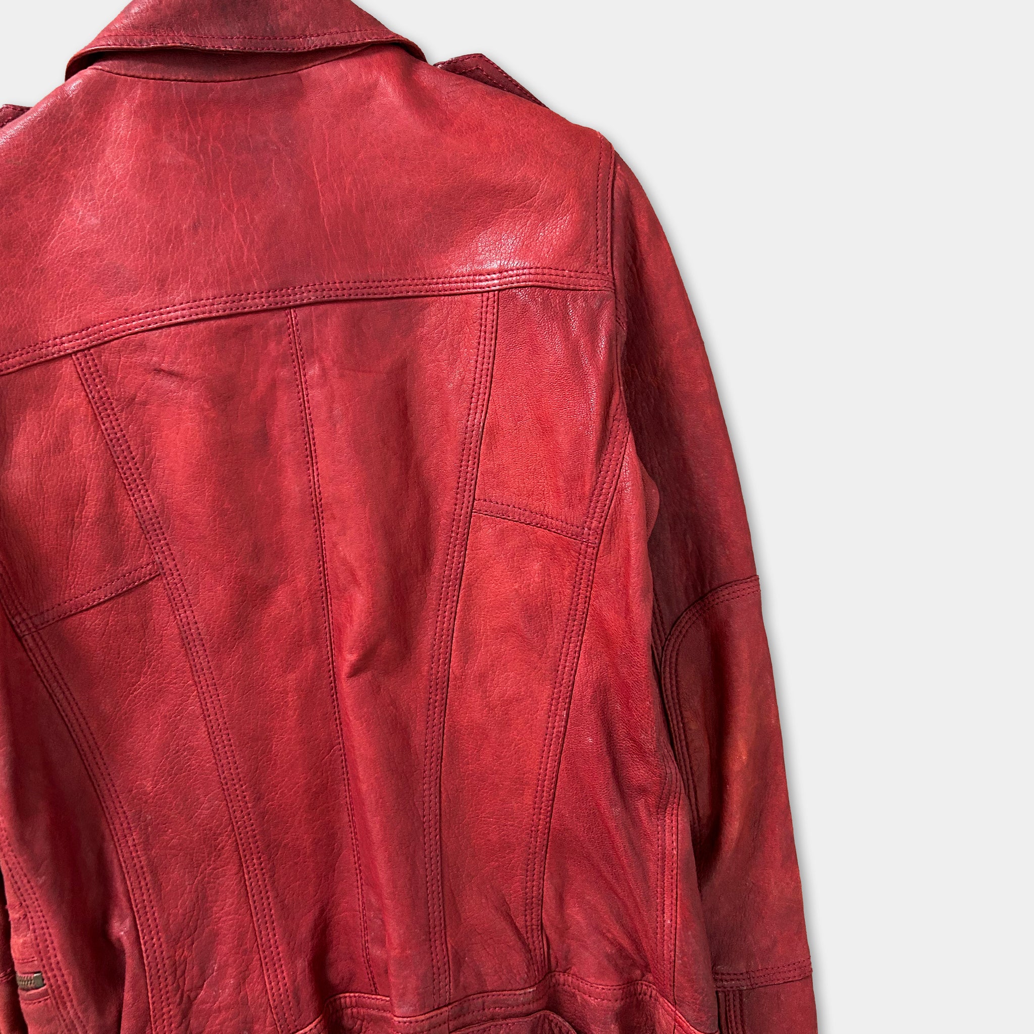 A close-up view of a red leather jacket, showing the back and the details of the jacket's design.
