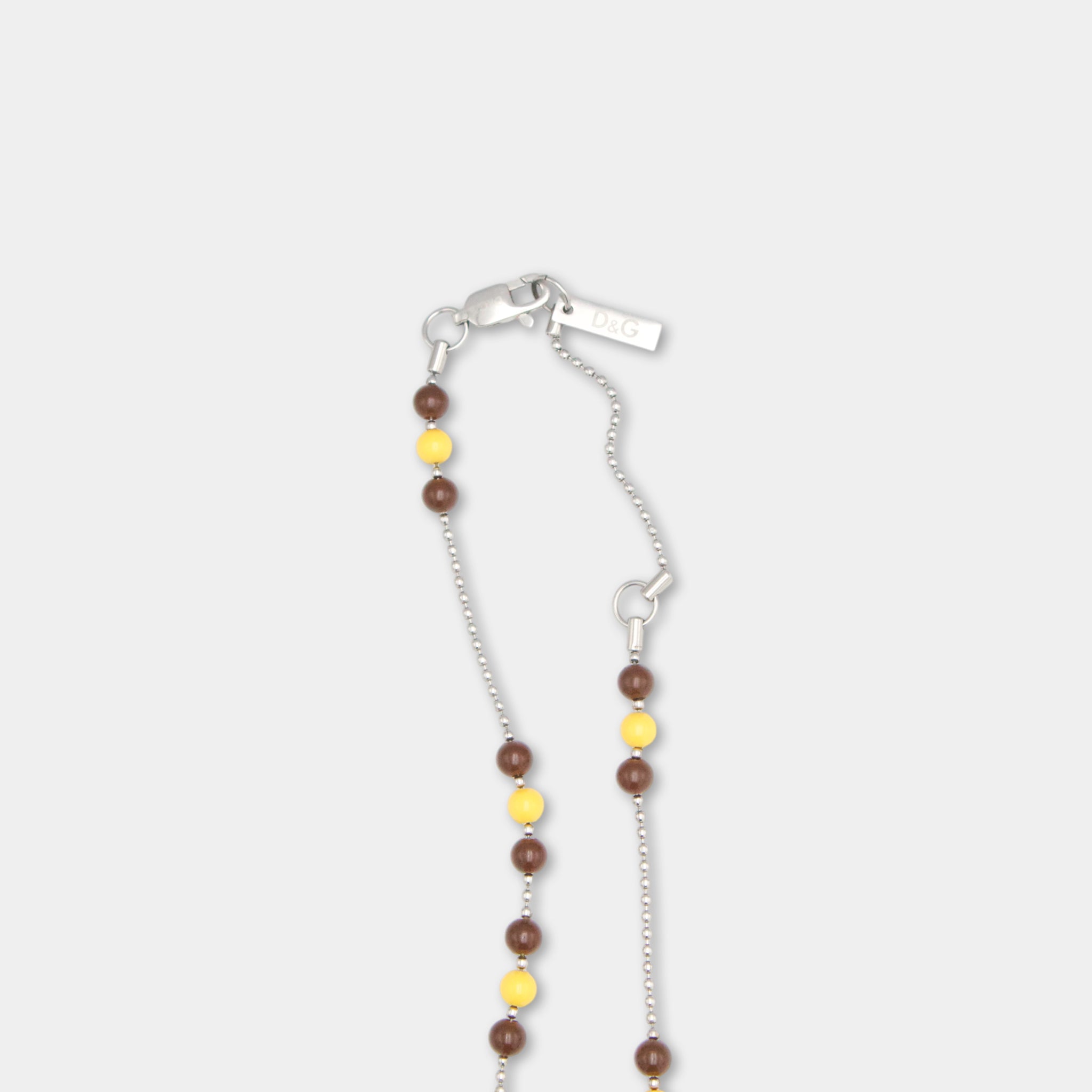 A necklace with a silver clasp and a small tag attached to it, featuring a combination of brown and yellow beads.