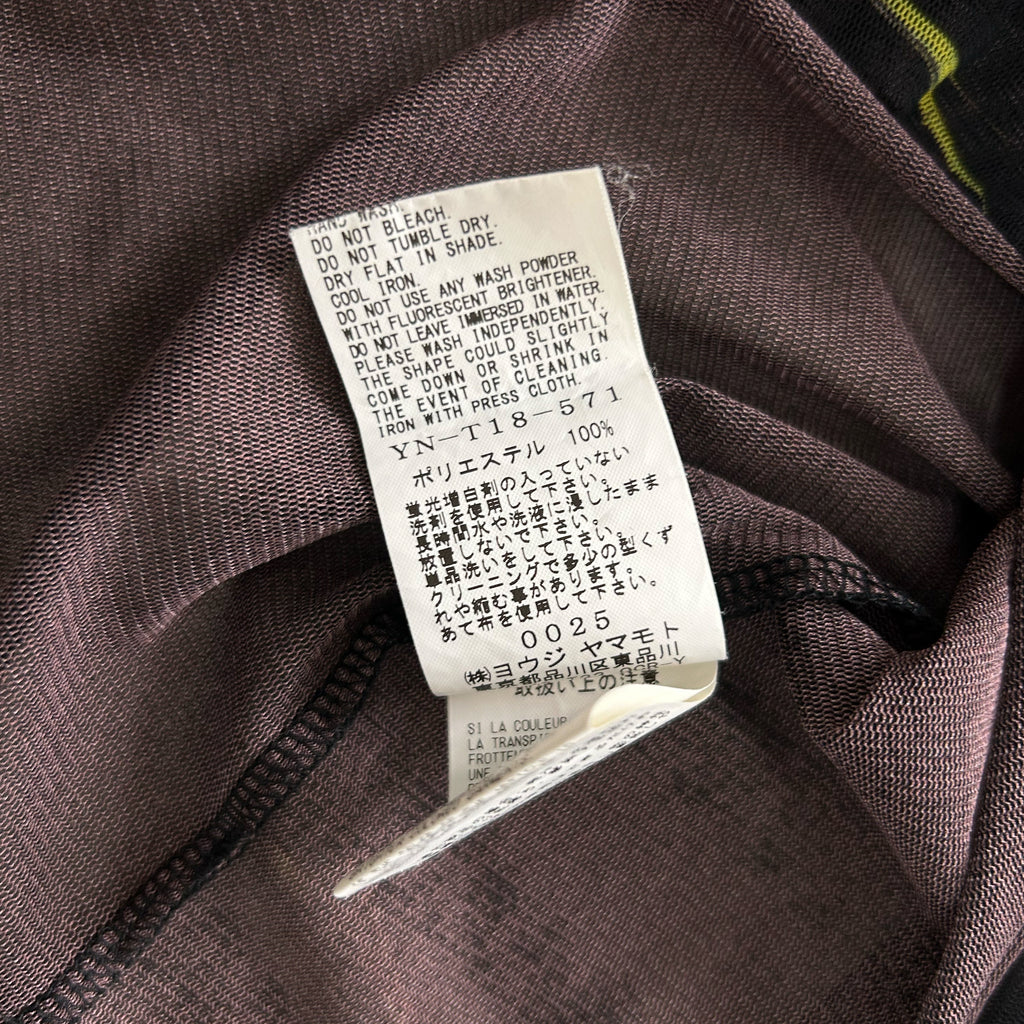a close-up view of a fabric label with text in Japanese, attached to a garment.